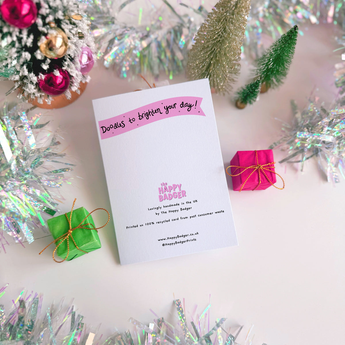 A pink Christmas card with an illustration of a goose with a red Santa hat on. The multicoloured text above the illustration reads 'have a honkingly great Christmas'.