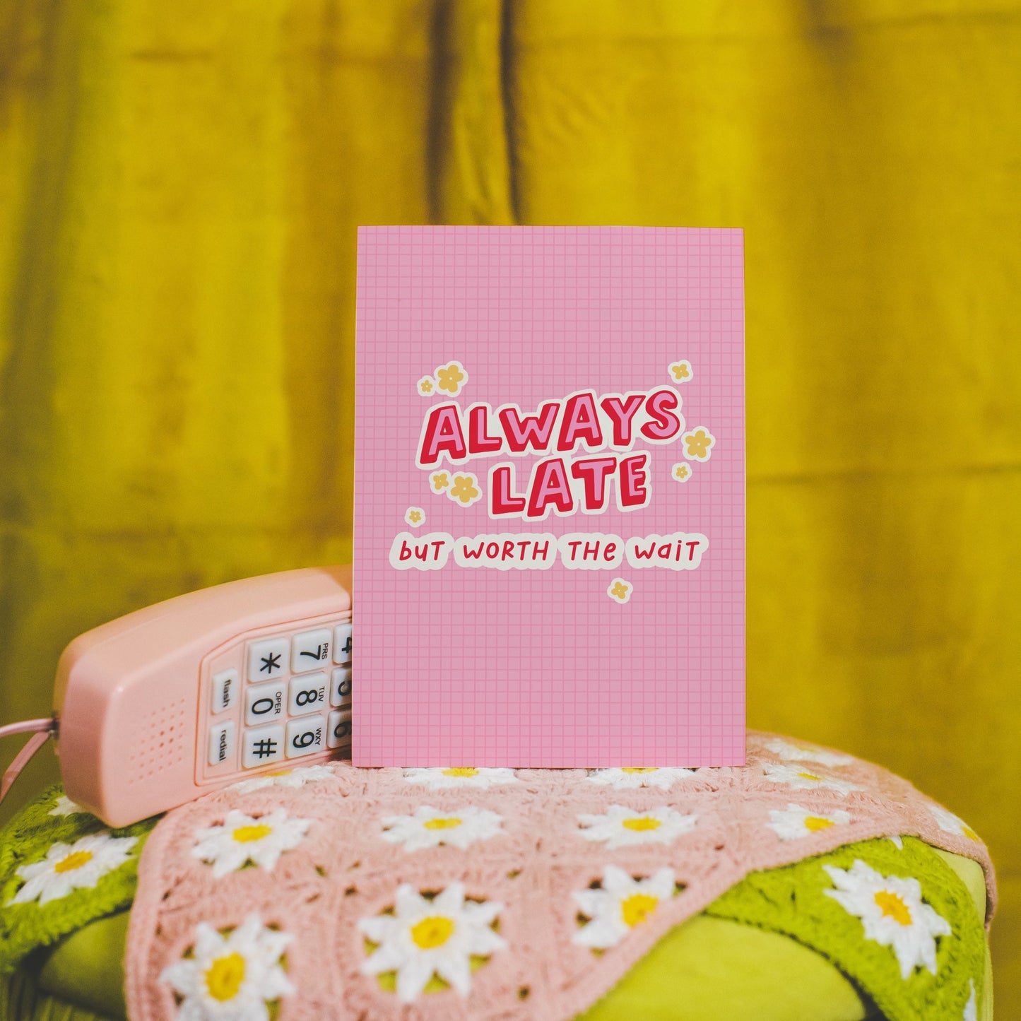 A colourful pink print with a quote saying always late but worth the wait in a contrasting red font.