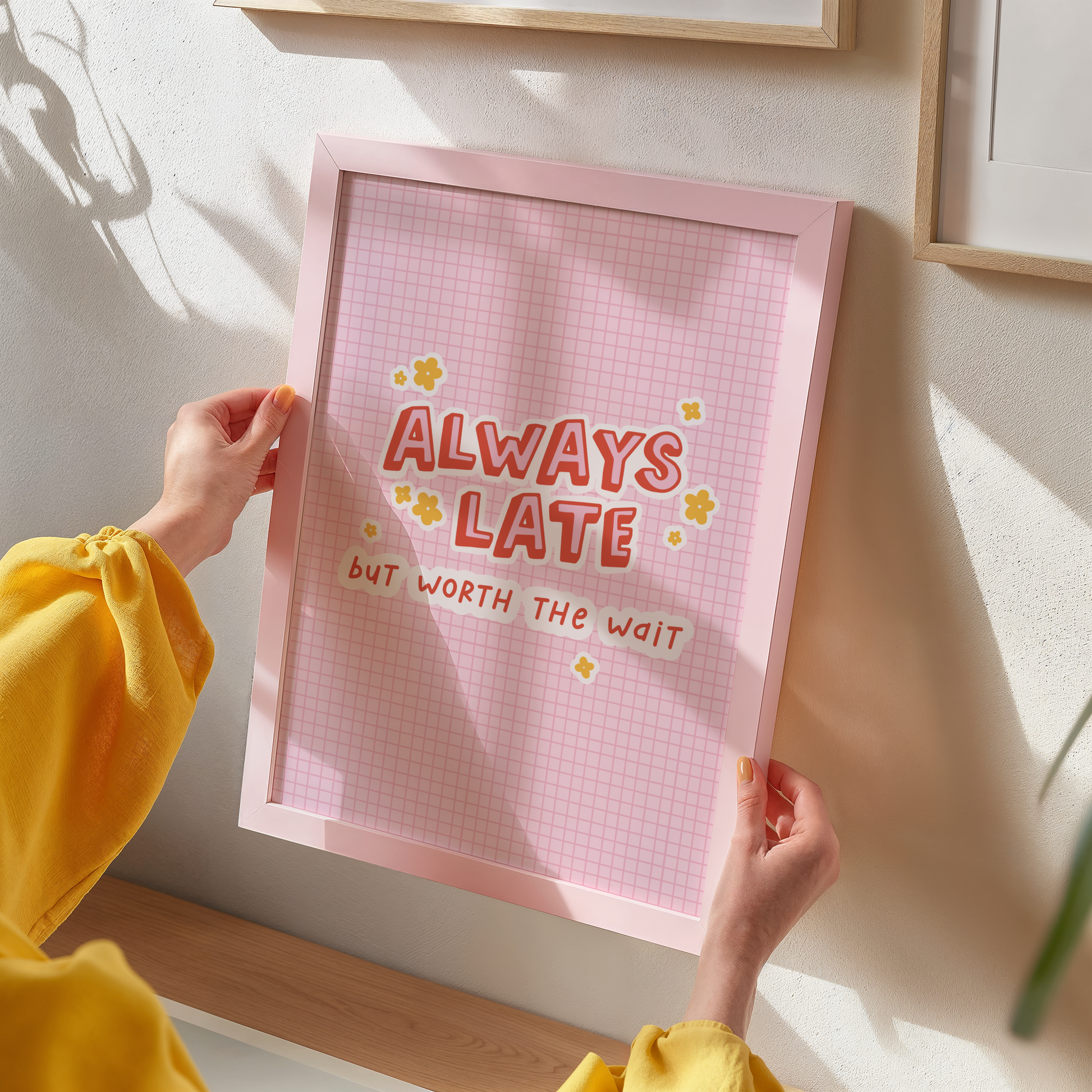 A colourful pink print with a quote saying always late but worth the wait in a contrasting red font.