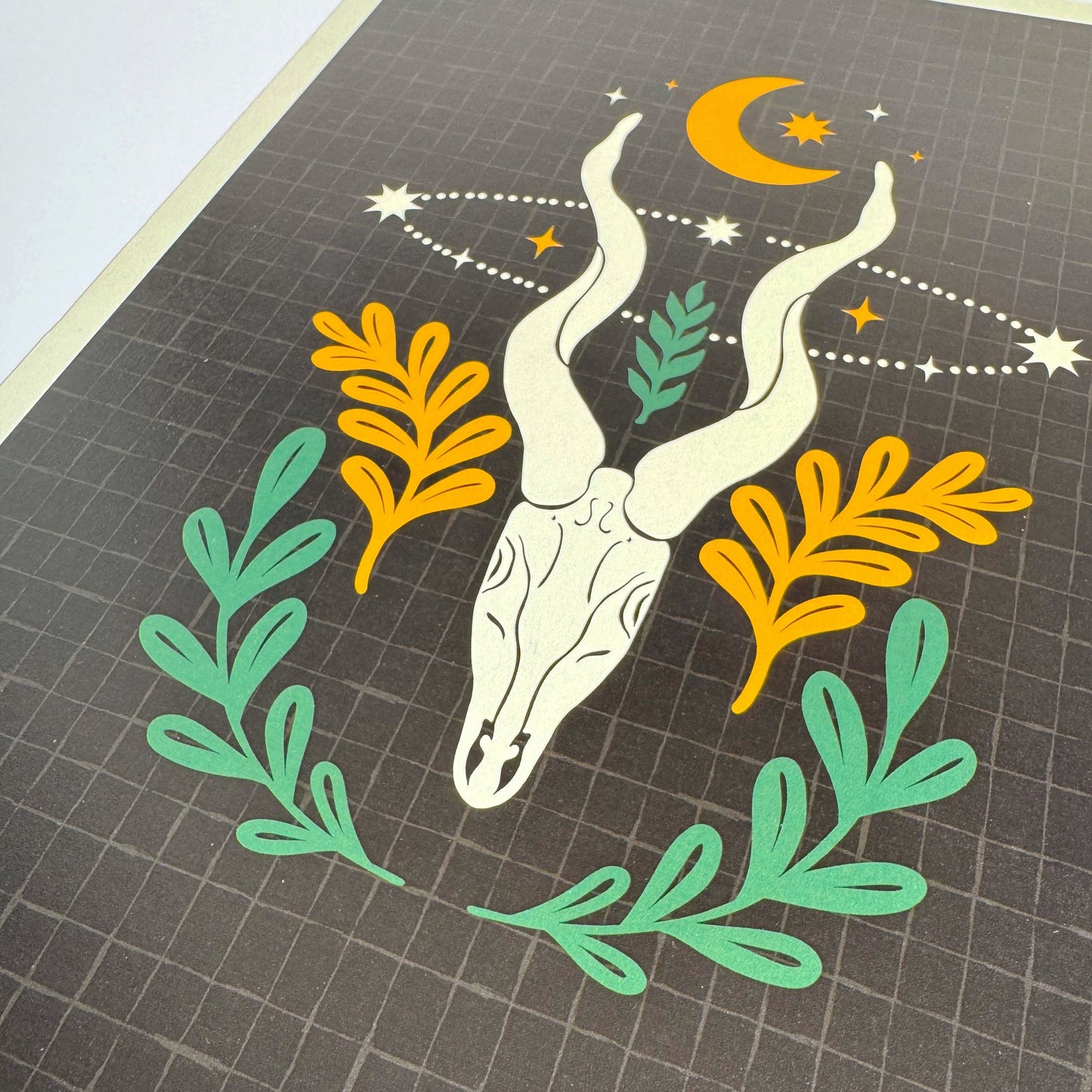 Decorative print with a deer skull design on a black background.