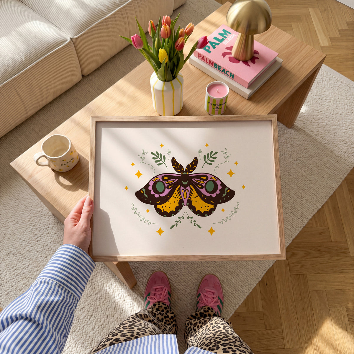 An illustration of a moth with ornate patterns on its wings. The colours are purple, mustard and teal with a neutral warm beige background.