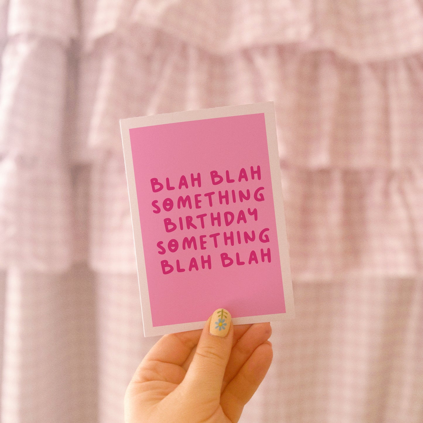 A birthday card, in pink, saying blah blah something birthday something blah blah