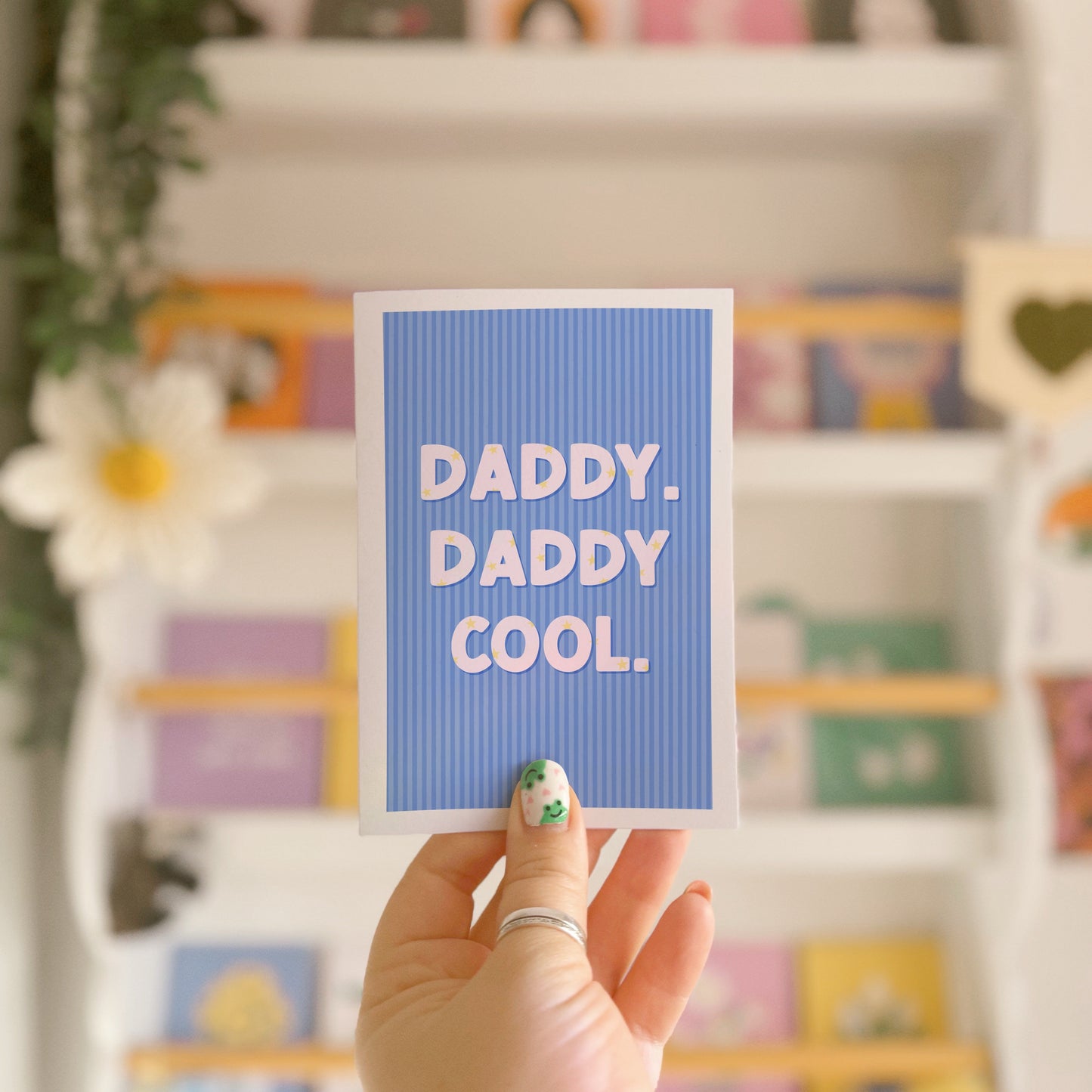 A blue striped card, with white text saying 'daddy. daddy cool.' on the front. The text has little stars within the letting as well.