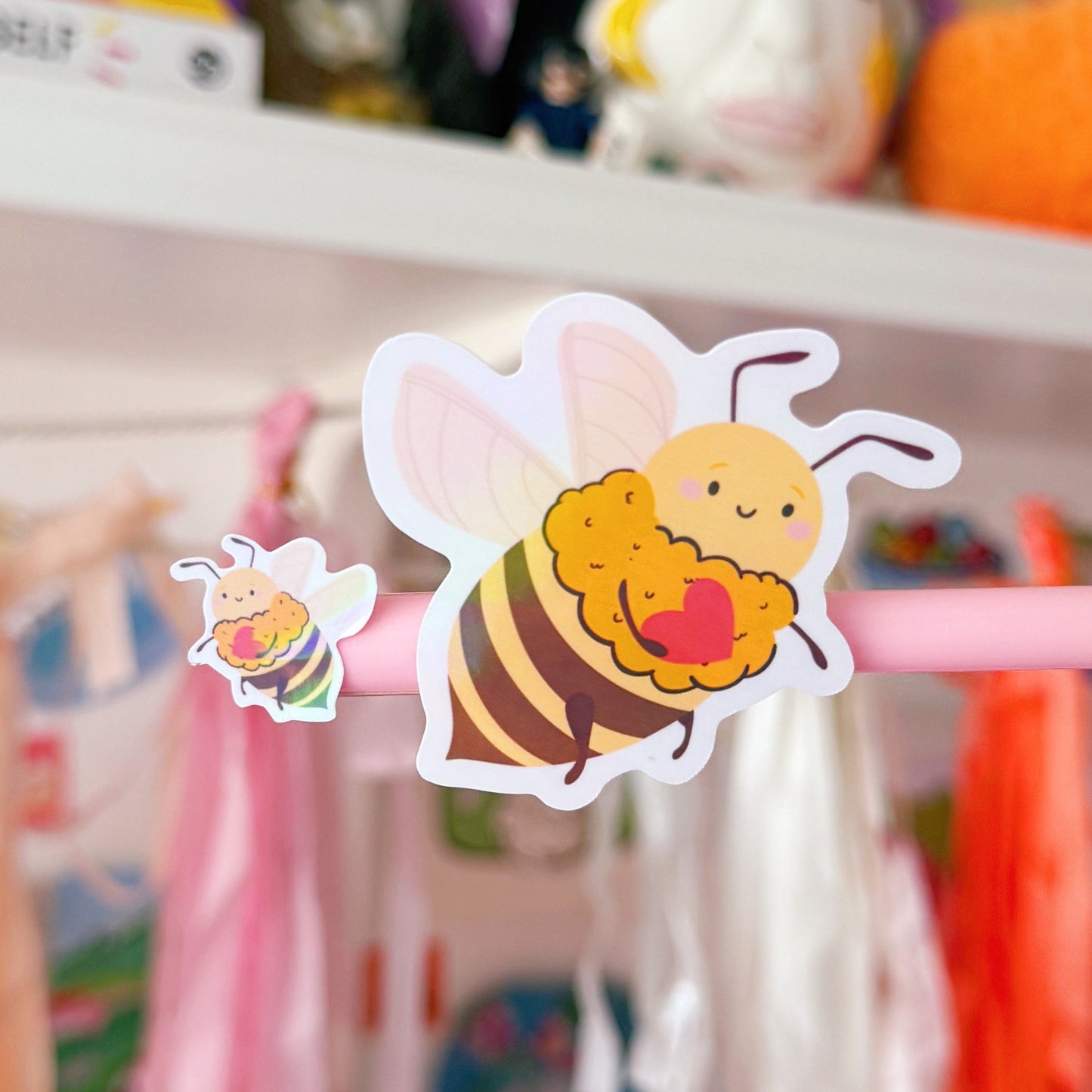 A close up of two bee stickers from the sticker sheet, one large and one small shown on a pen lid for scale.