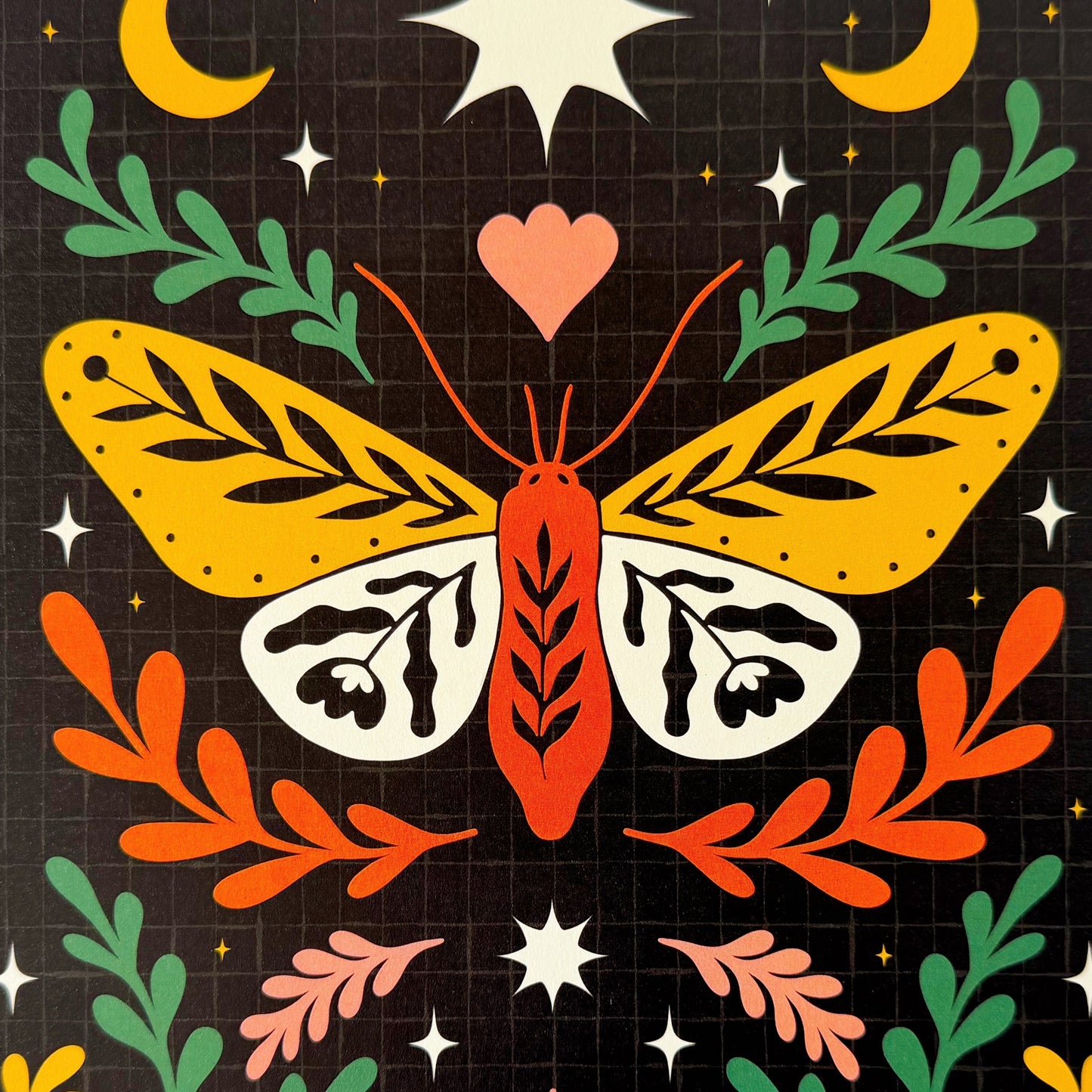 A close up of a dark celestial print, with an illustration of a moth on.