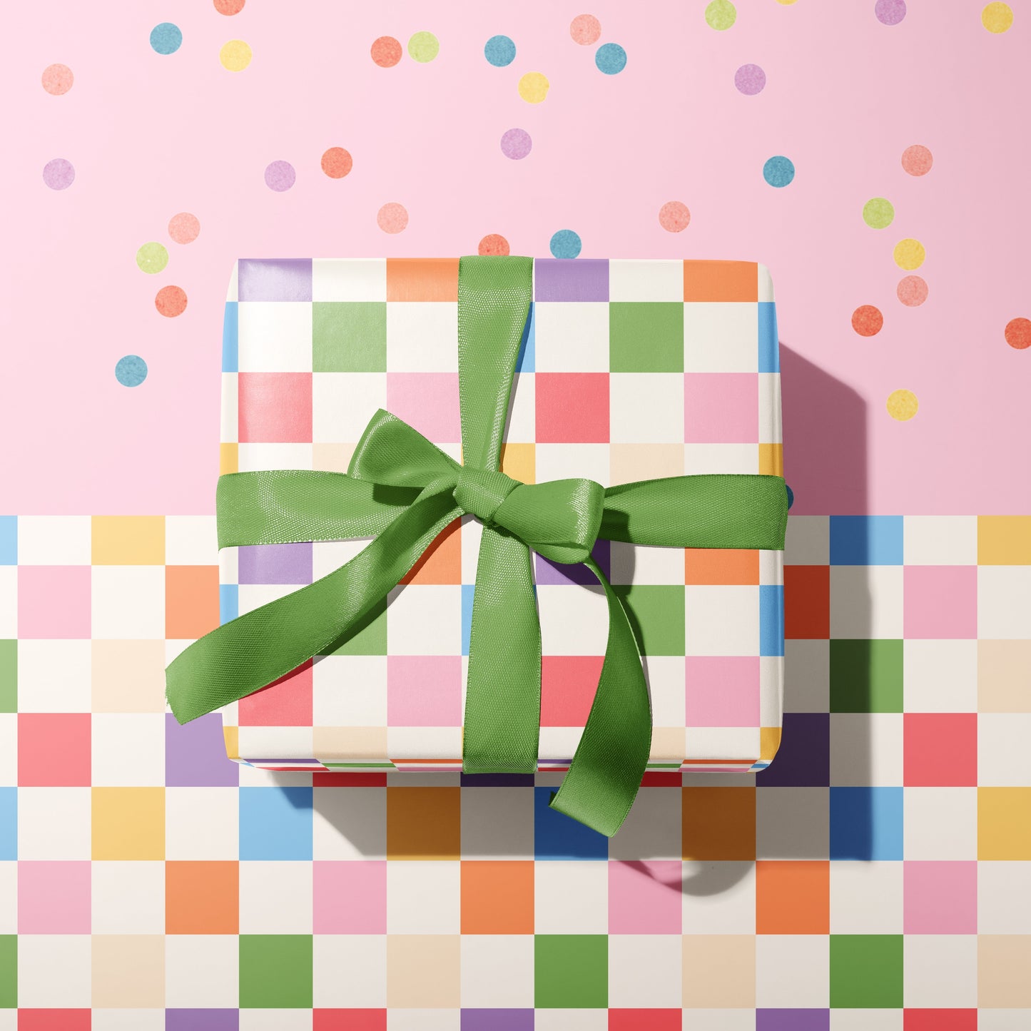 A multicoloured checkerboard pattern gift wrap, shown wrapped around a gift with blue ribbon.