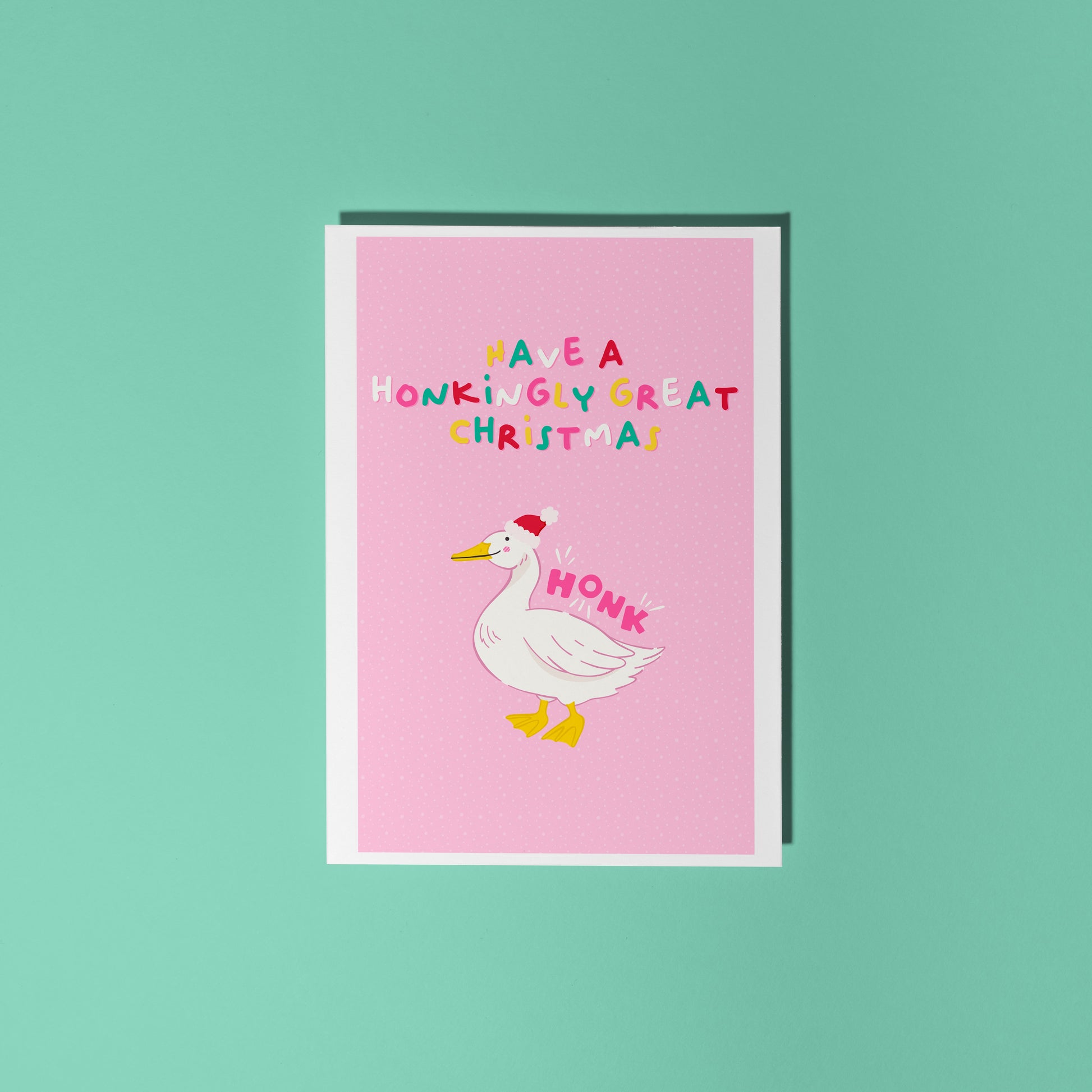 Pink Christmas card with a goose illustration and text that reads 'have a honkingly great christmas' above.