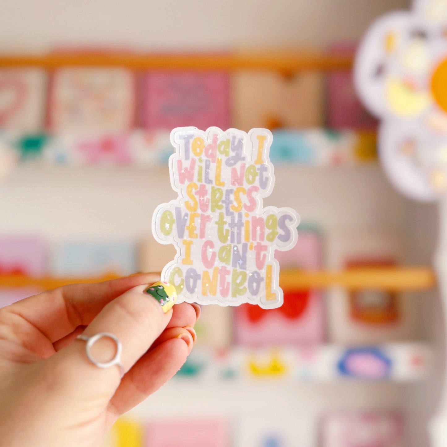 A holographic sticker, with the quote today I will not stress over things I can't control on it. The sticker has an easy peel lip.