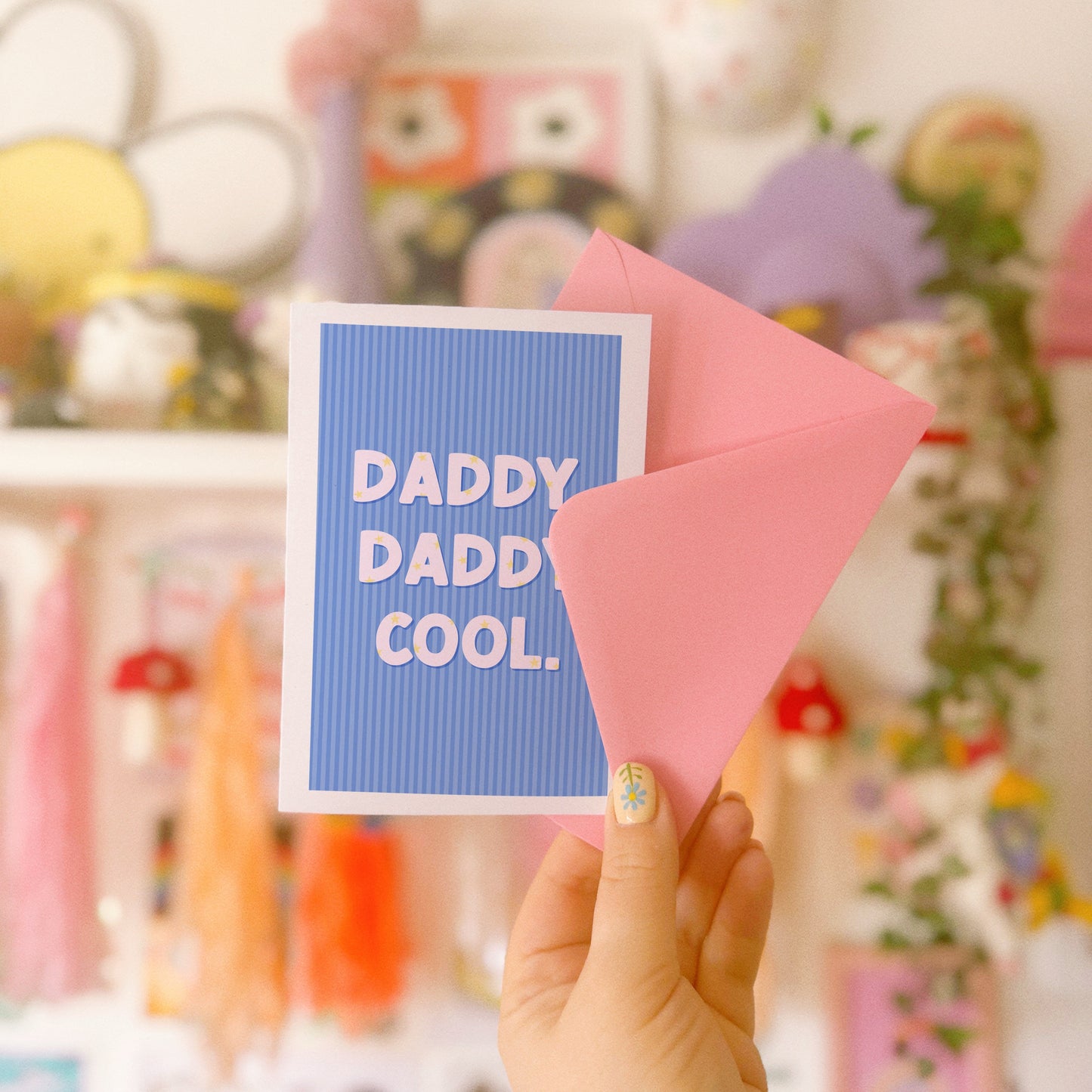A blue striped card, with white text saying 'daddy. daddy cool.' on the front. The text has little stars within the letting as well.