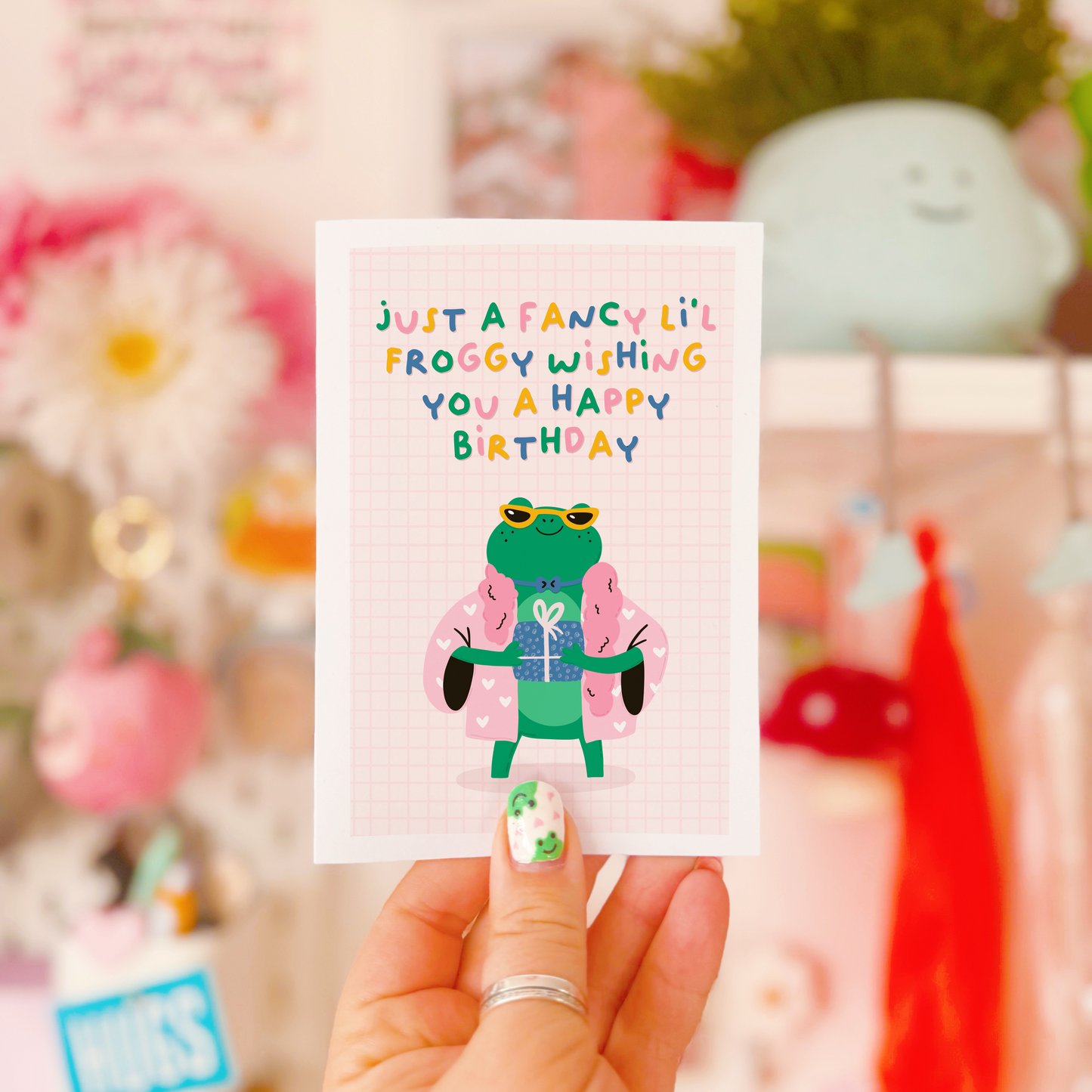 A cute birthday card with an illustration of a fancy looking frog holding a birthday present and the text reads 'just a fancy little froggy wishing you a happy birthday'