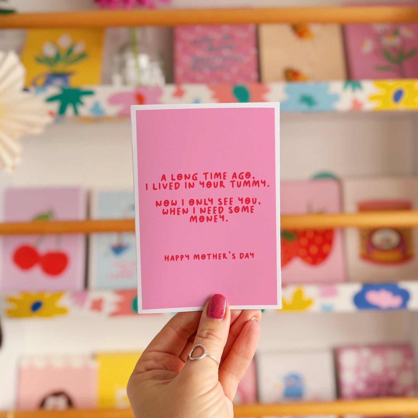 A pink Mother's Day card with a funny quote, that says 'A long time ago I lived in your tummy. Now I only see you, when I need some money. Happy Mother's Day".