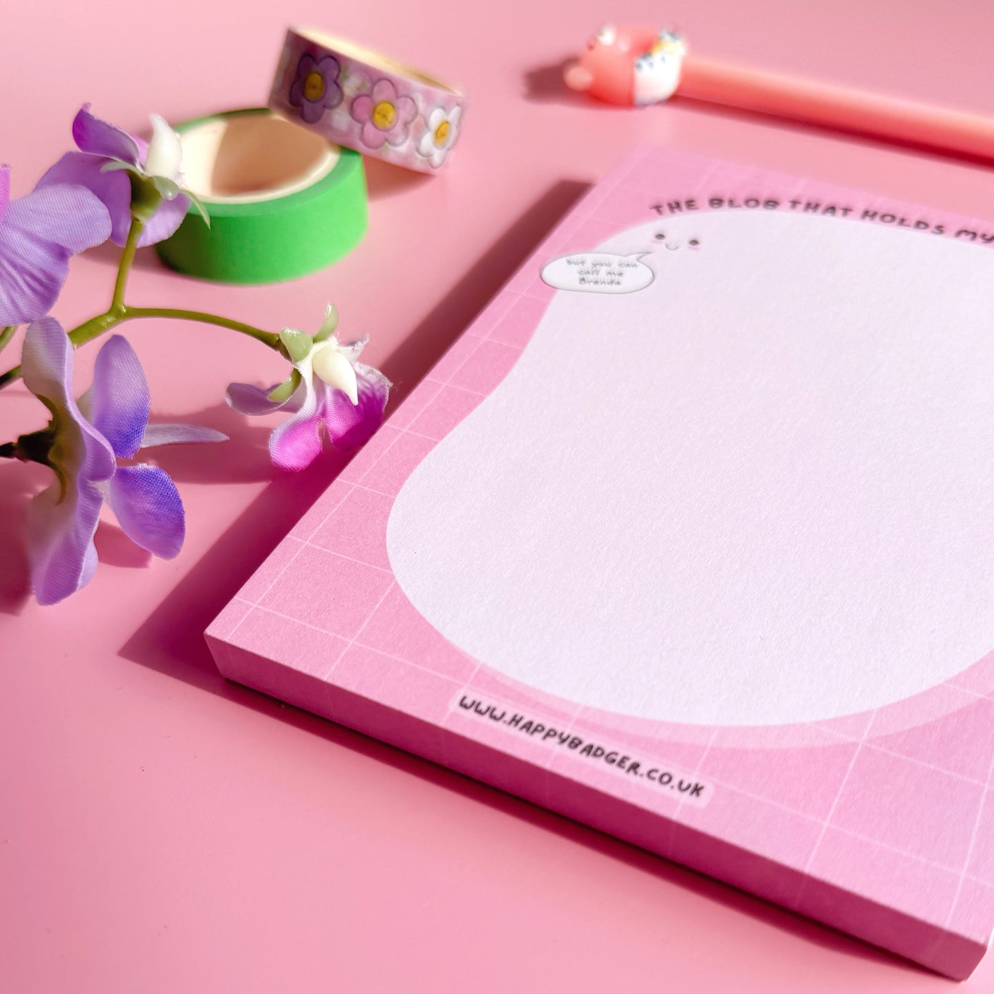 Pink notepad with floral design on a pink background