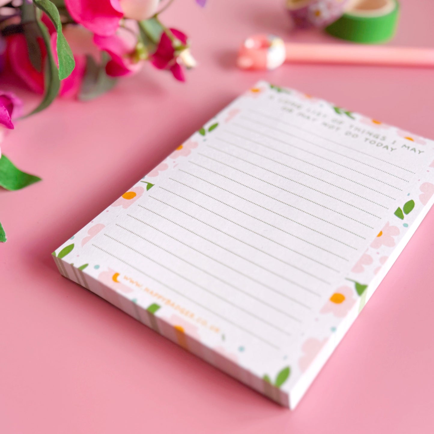 Notepad with floral design on a pink background