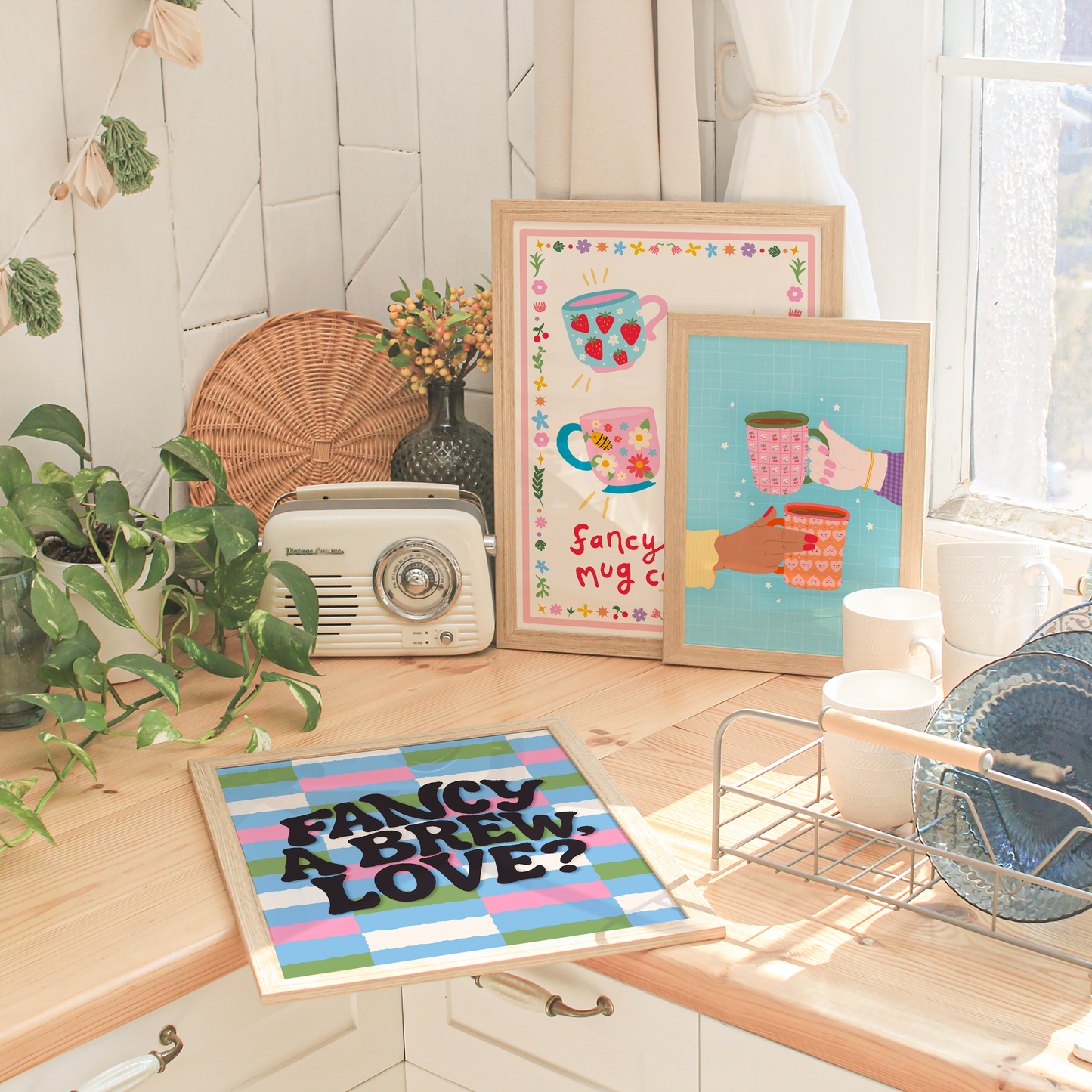 A collection of three colourful kitchen themed wall art prints sat on a kitchen counter top.