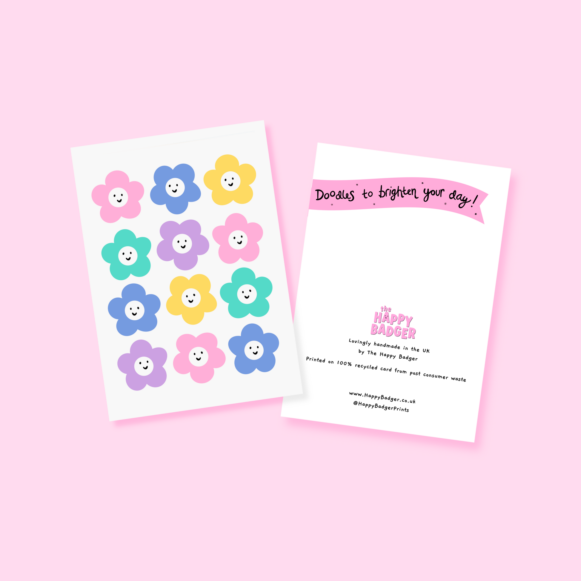 A white card with 12 colourful smiling daisy-like flowers on the front.