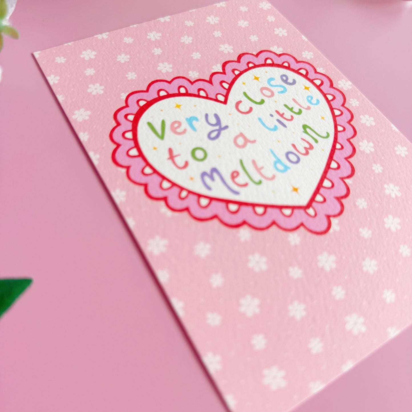 Heart-shaped card with colorful text on a pink background