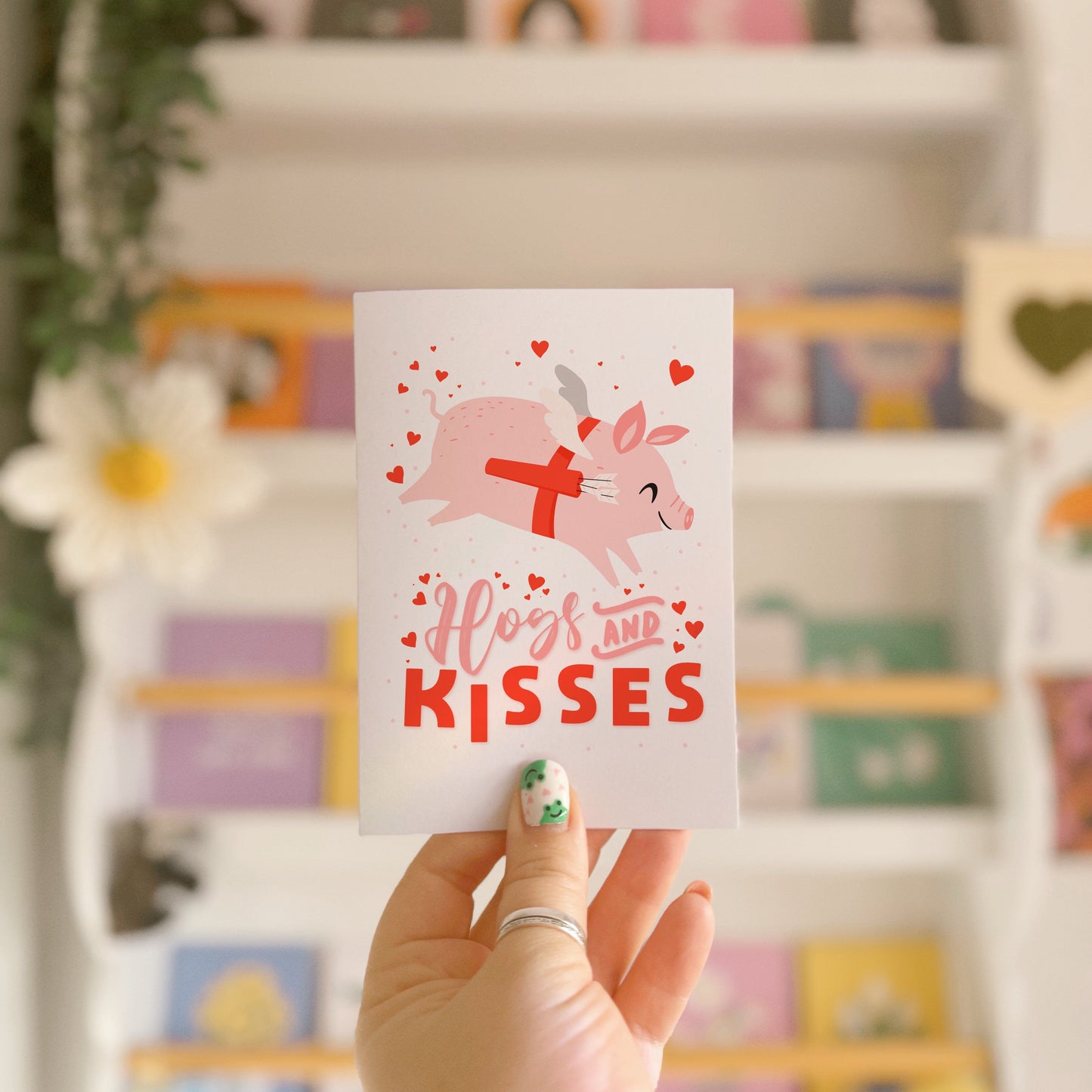 A love themed card, with a flying pig dressed as cupid and the words 'Hogs and kisses' underneath.