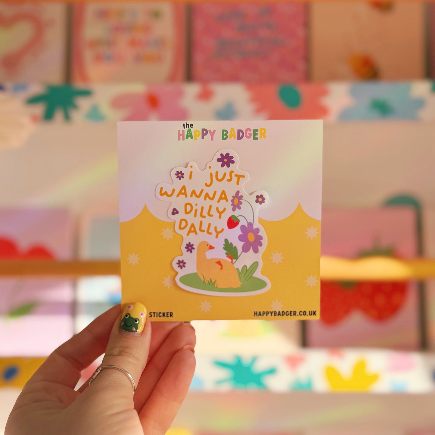 A waterproof vinyl sticker with a duck lazing amongst flowers, with text that reads 'I just wanna dilly dally'.