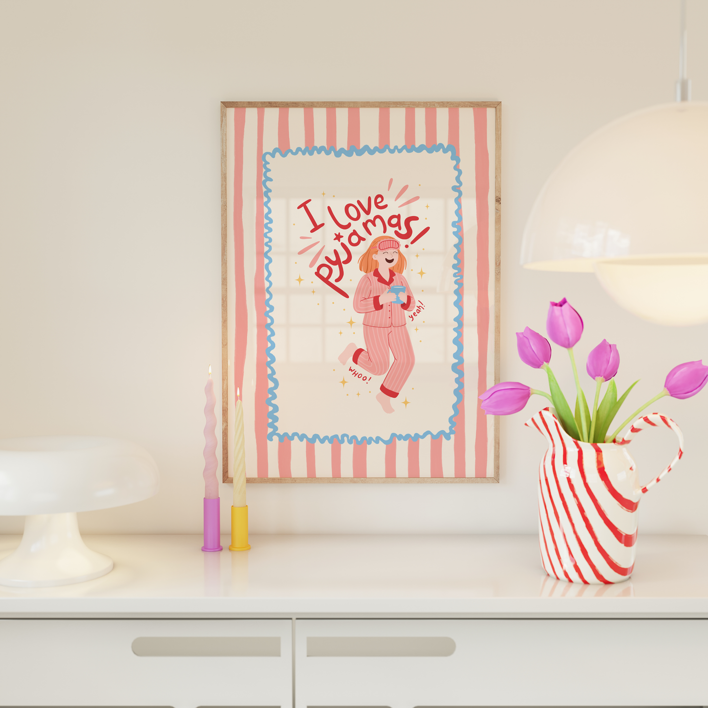 Framed artwork with 'I Love Pyjamas' design on a shelf with decorative items.