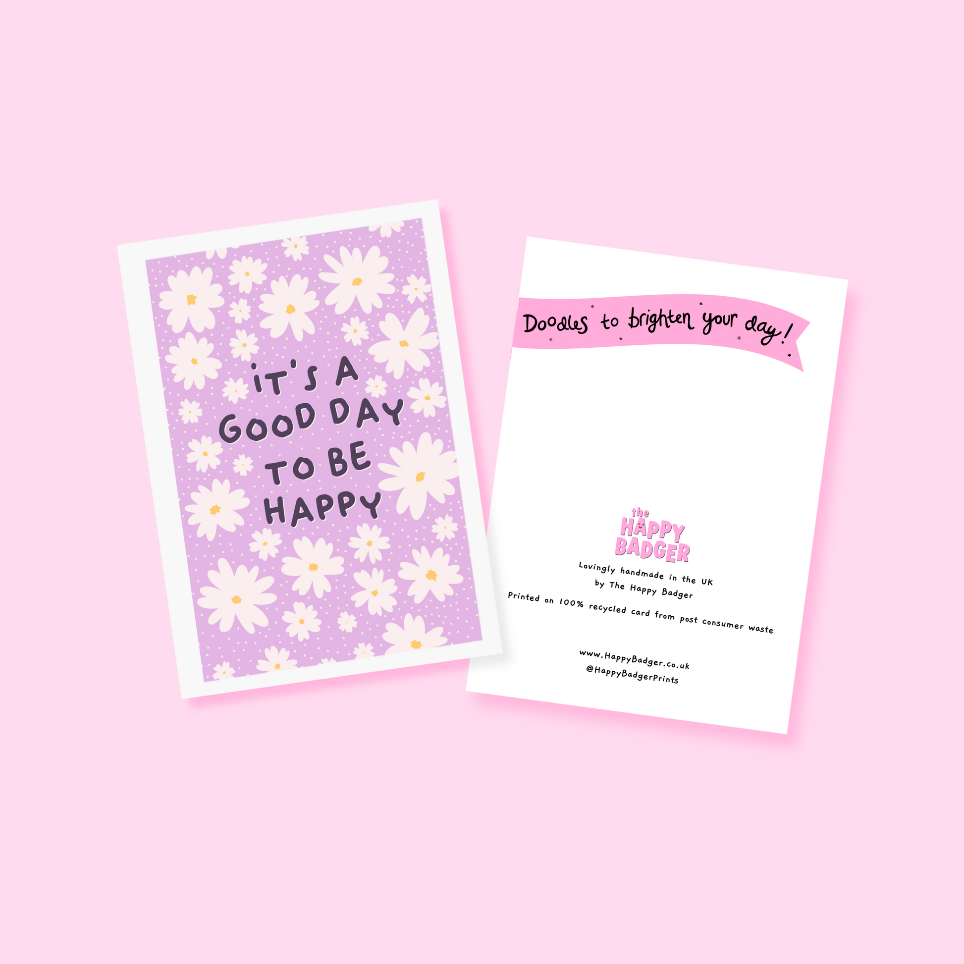 A purple card, with a white daisy pattern all over and the words 'it's a good day to be happy' in the centre.