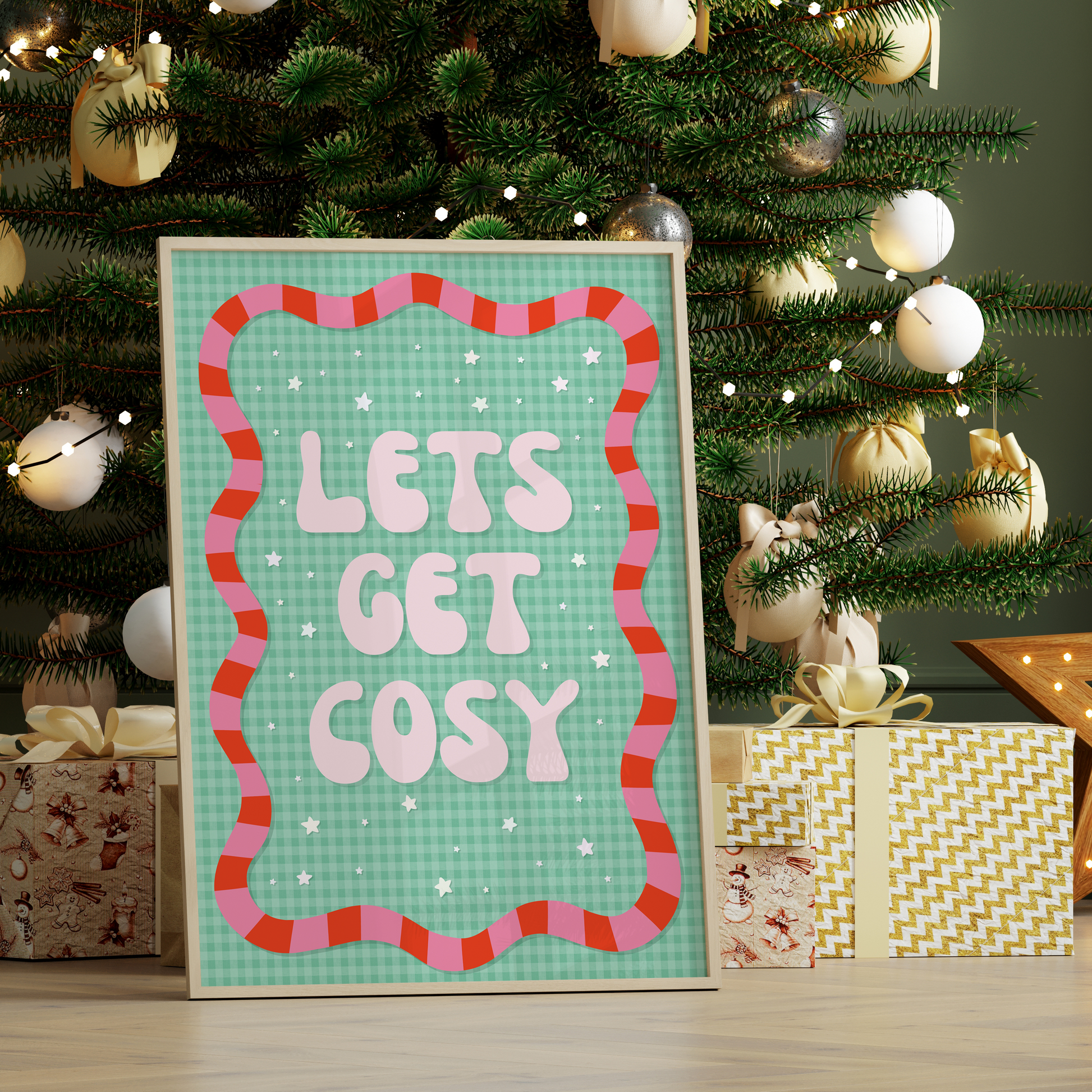 Decorative print with 'Let's Get Cosy' text in front of a Christmas tree with lights and presents.