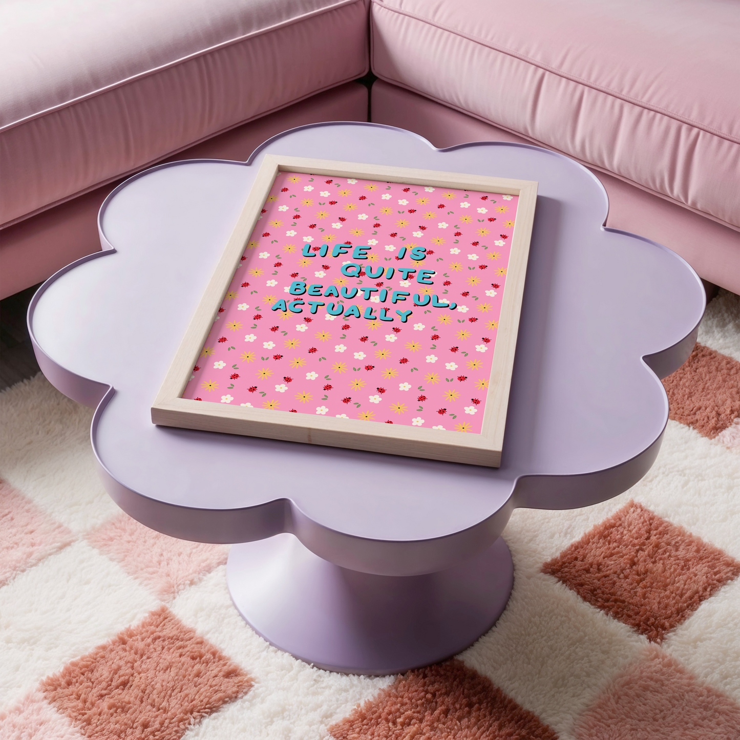 A pink patterned print, with little white and yellow flowers and small lady birds. In the centre of the print in handwriting, are the words 'life is quite beautiful, actually'.