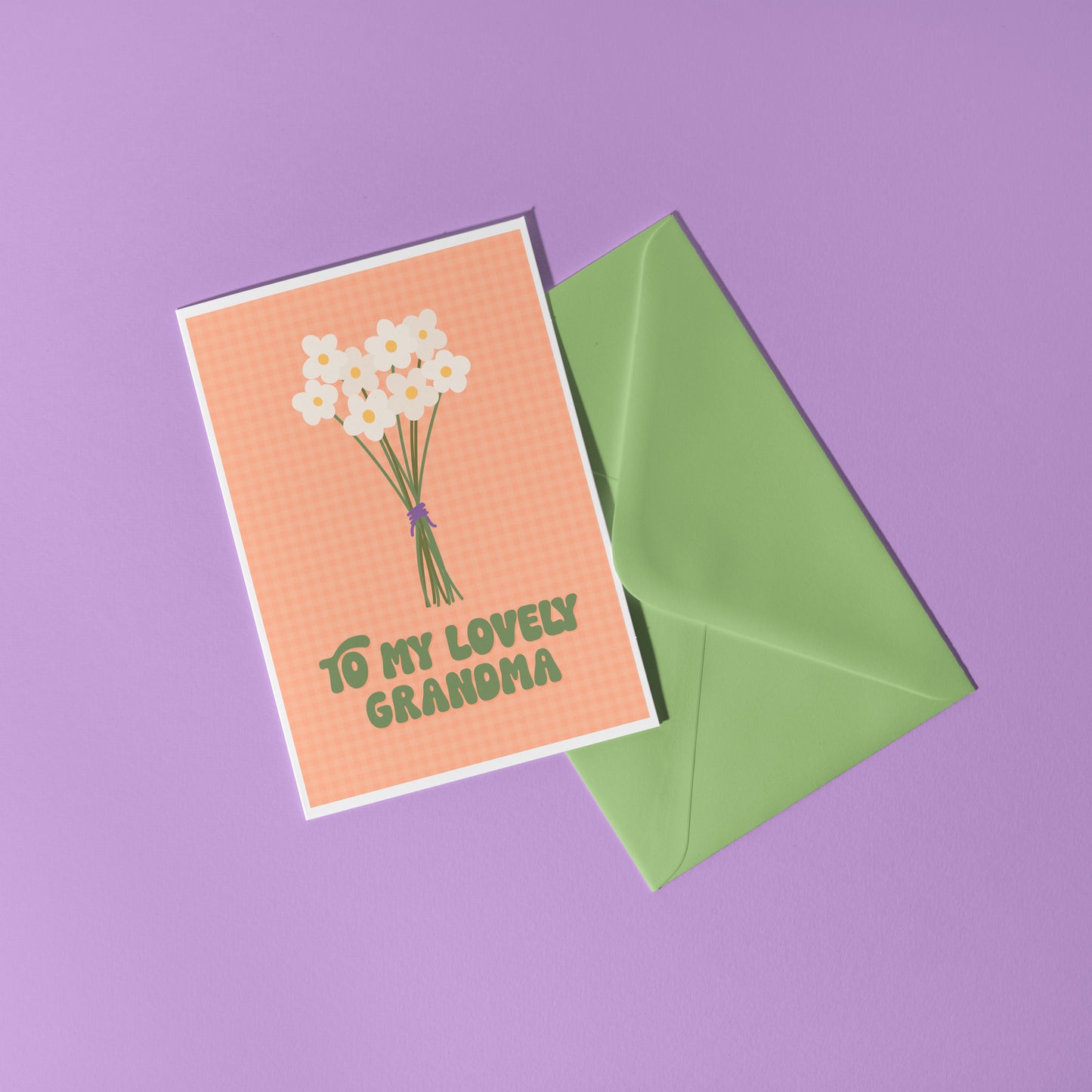 An orange greeting card with the words 'to my lovely Grandma' on the front, with a bunch of daisies.