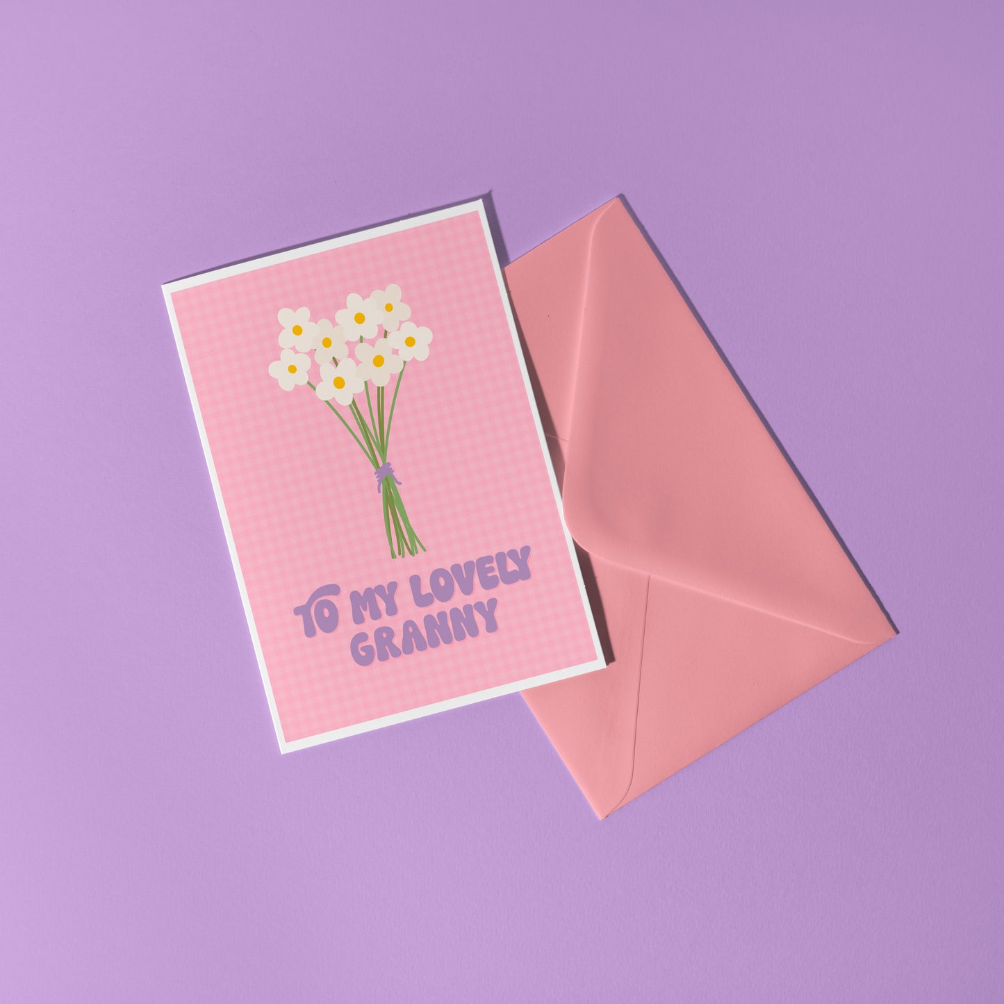 A pink greeting card with the words 'to my lovely Granny' on the front, with a bunch of daisies.