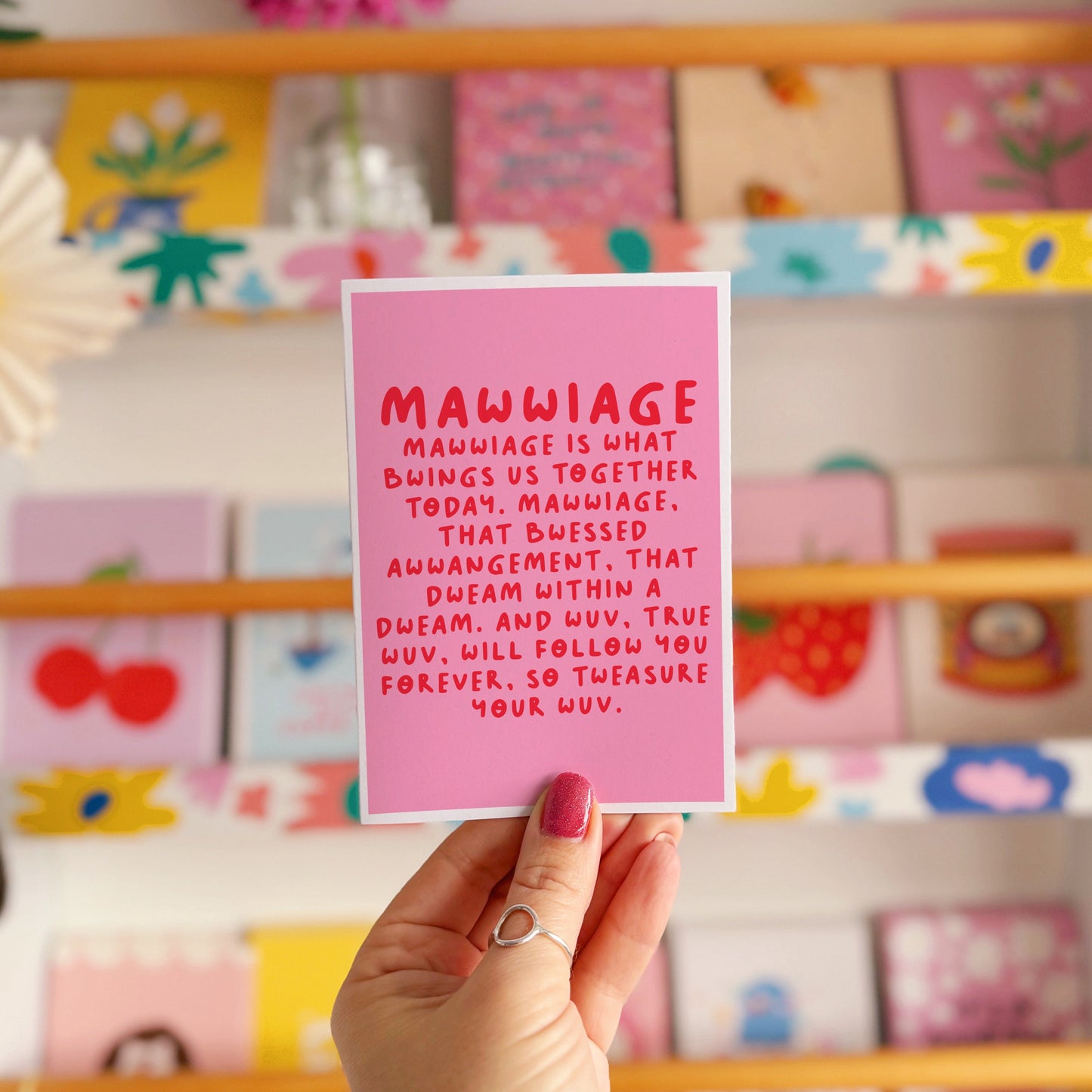 A pink wedding day celebration card, with a quote in red, from the film The Princess Bride.