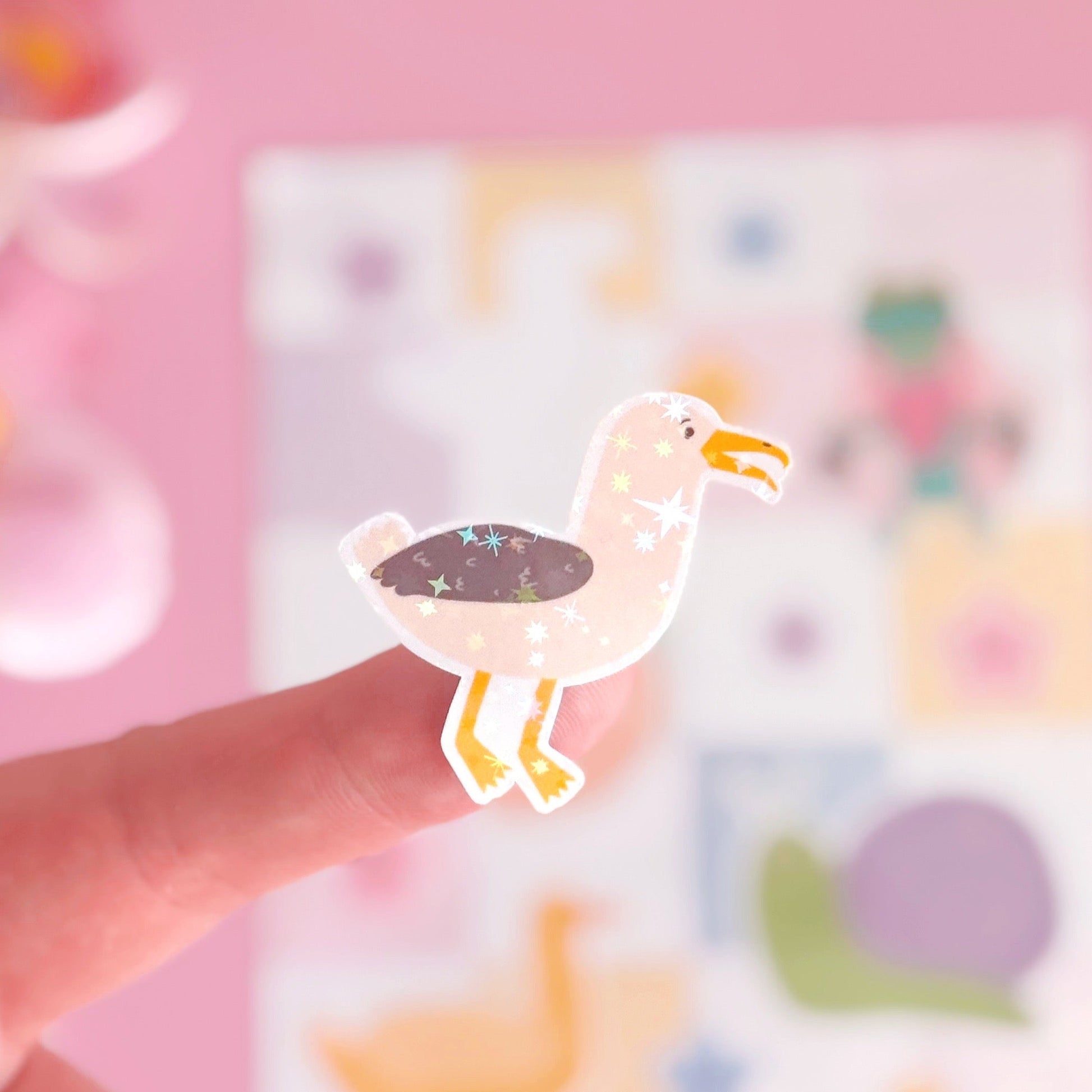 A sticker from the mini sticker pals sticker sheet. This is a seagull, coated with a holographic laminate with little starbursts on.