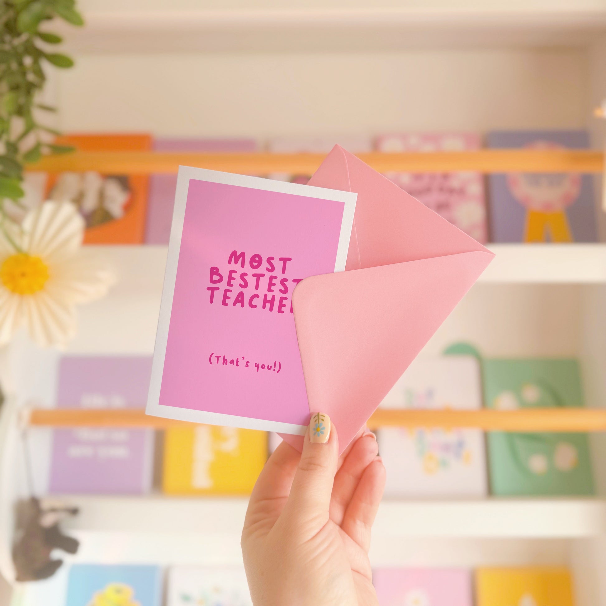 A pink thank you card for a teacher, that says 'most bestest teacher' and underneath in smaller text says 'that's you!)