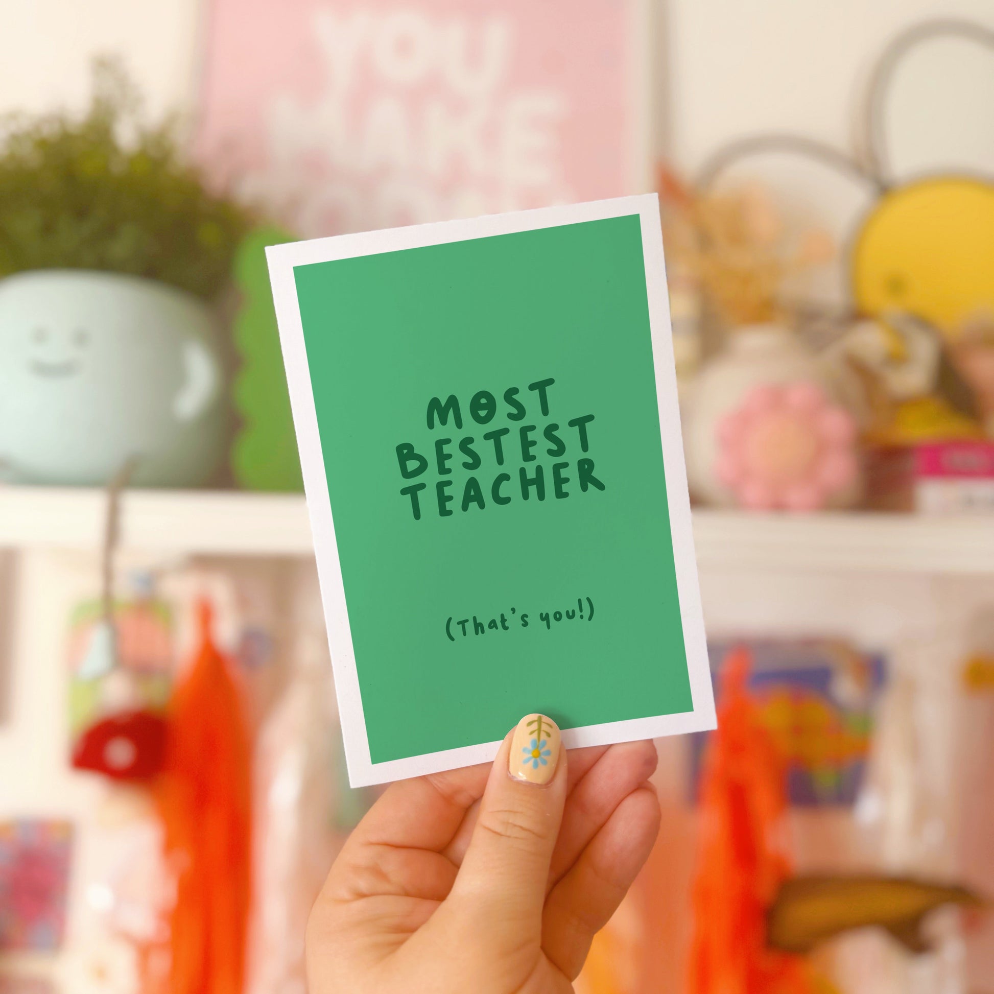 A green thank you card for a teacher, that says 'most bestest teacher' and underneath in smaller text says 'that's you!)