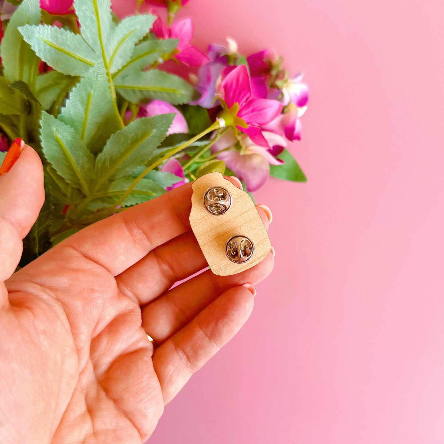 The back of our mushroom terrarium pin badge, with two metal clasp fastenings.