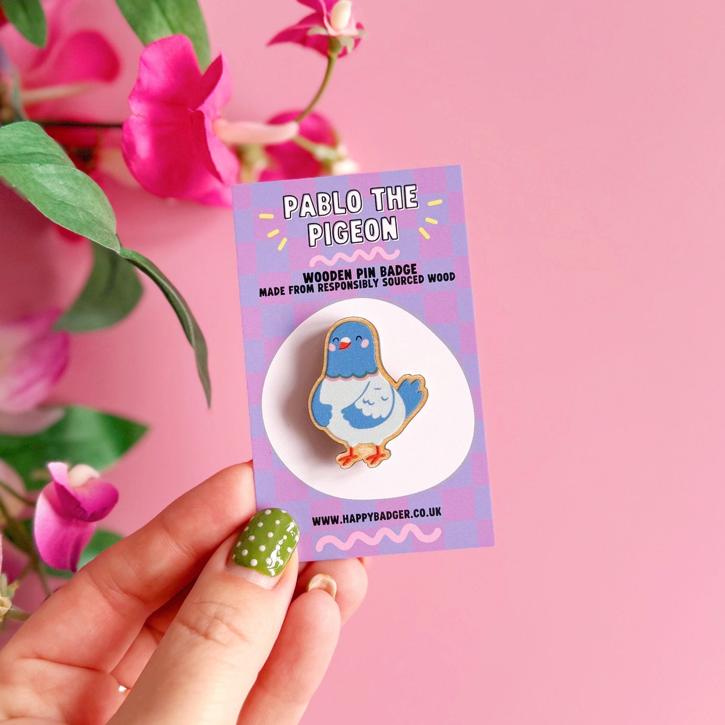 A blue illustrated pigeon pin badge, drawn in a cute character style. Shown with a coordinating backing card.