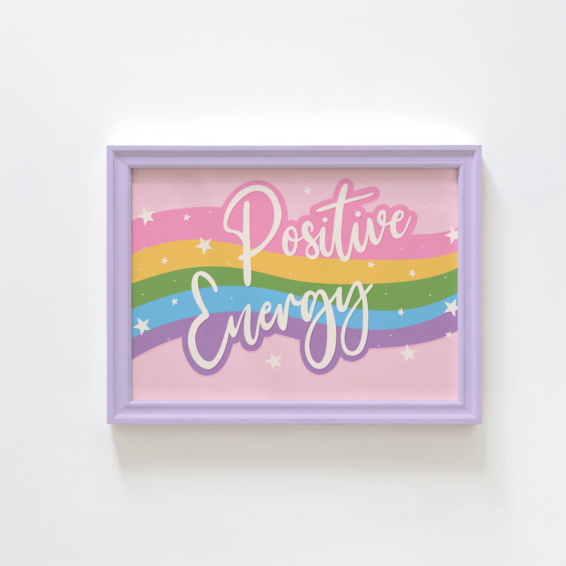 A bright print, with a pink, yellow, green blue and purple wave across the centre and the words 'positive energy' hand written in white across the top.
