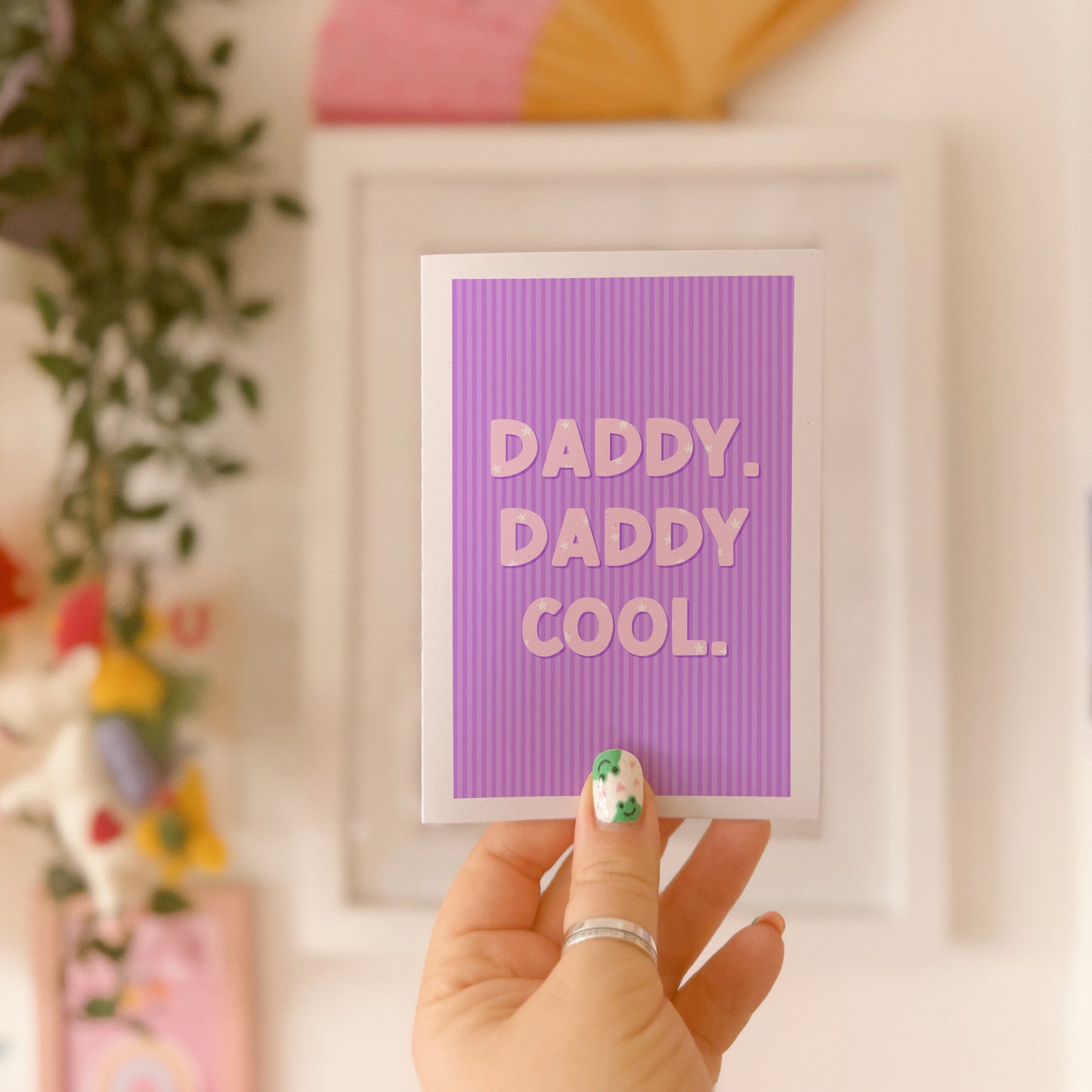 A purple striped card, with white text saying 'daddy. daddy cool.' on the front. The text has little stars within the letting as well.