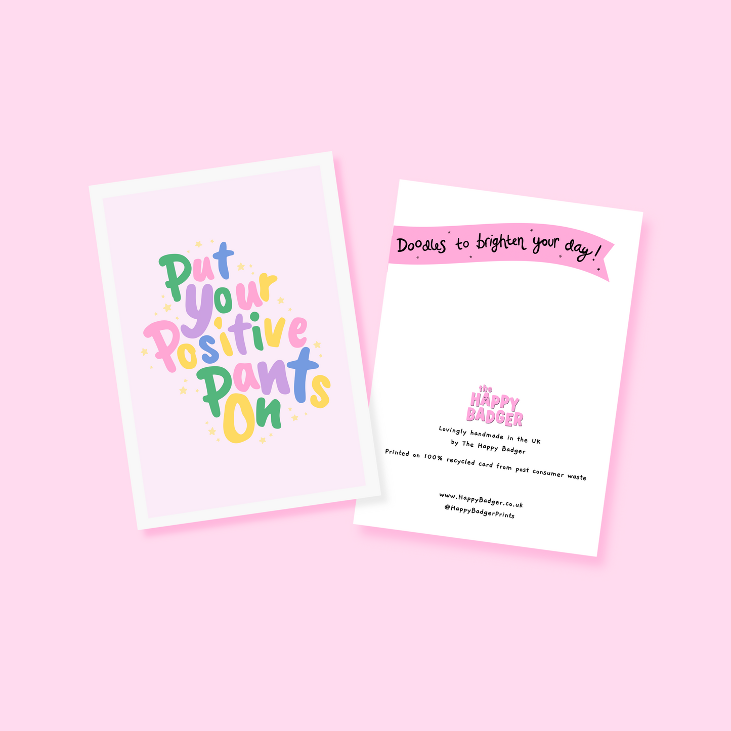 A colourful card with hand lettered text, saying 'put your positive pants on' on a light pink background.