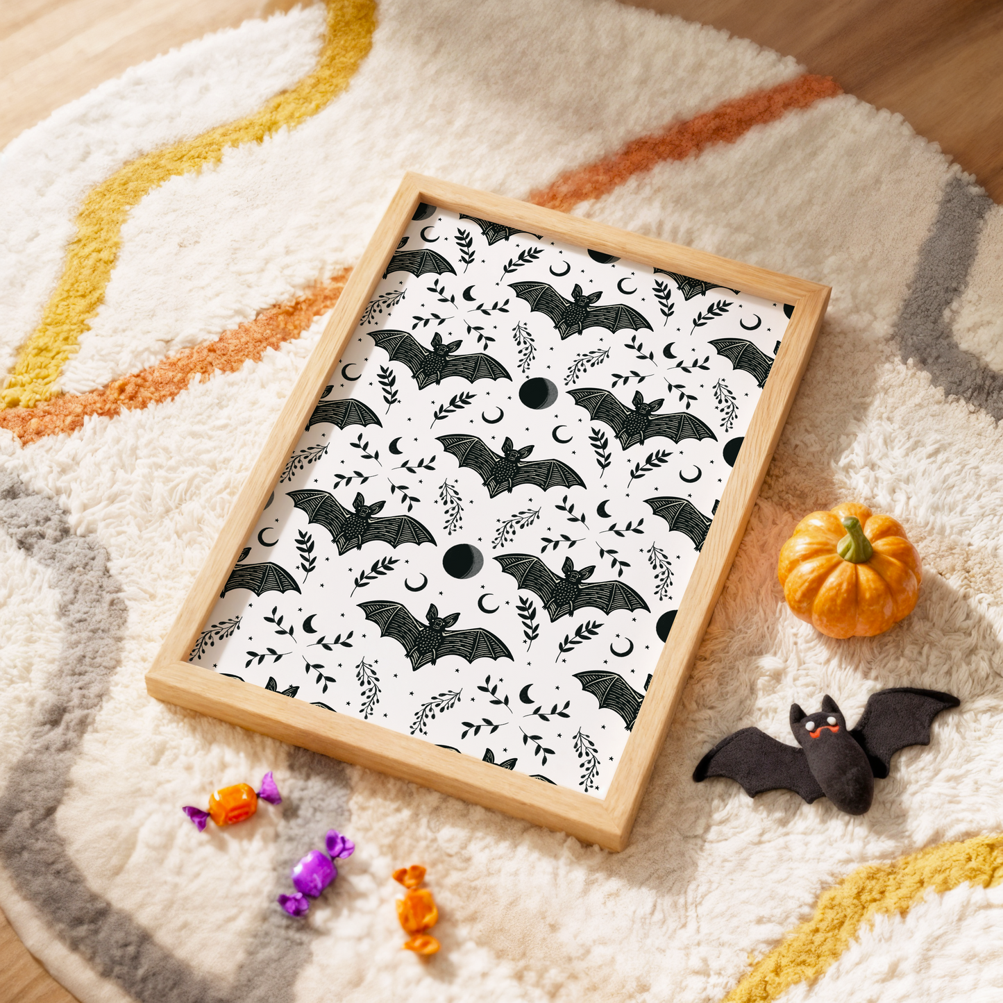 A halloween themed print with a repeating pattern of spooky bats, leaves and moons.