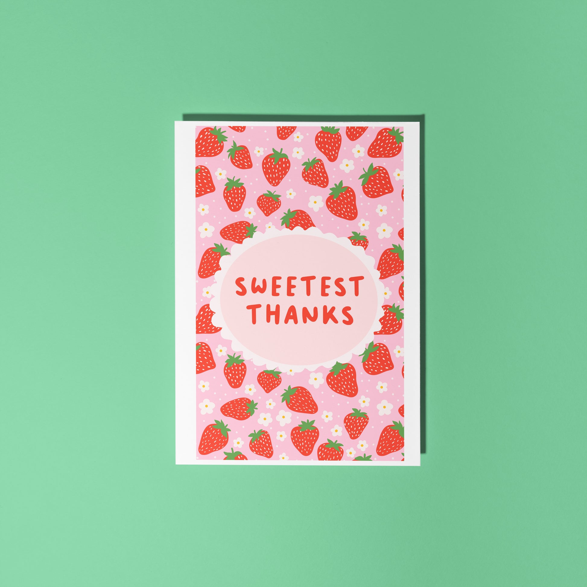 A thank you card with a strawberry pattern, and a small oval in the centre with the text 'Sweetest Thanks' in the centre.