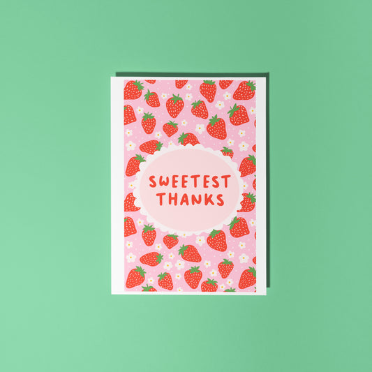 A thank you card with a strawberry pattern, and a small oval in the centre with the text 'Sweetest Thanks' in the centre.