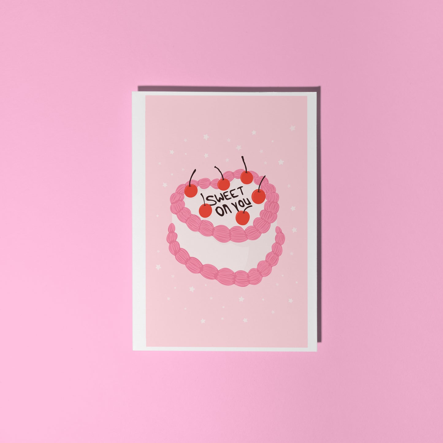 A pink greetings card with an illustration of a cake with pink and white icing, that says 'sweet on you' on the top of the cake.