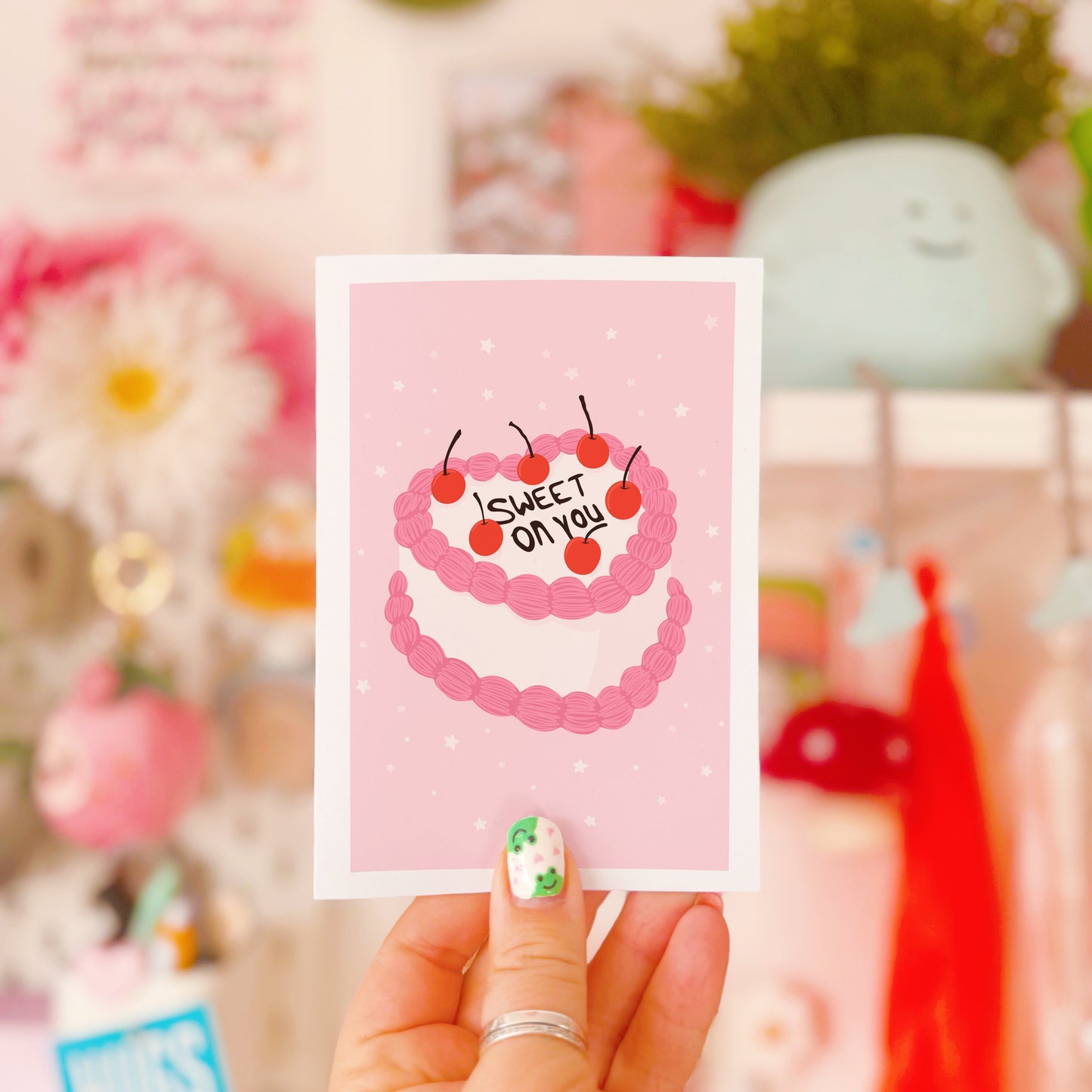 A card with a pink and white cake, saying 'Sweet on you' on the top.