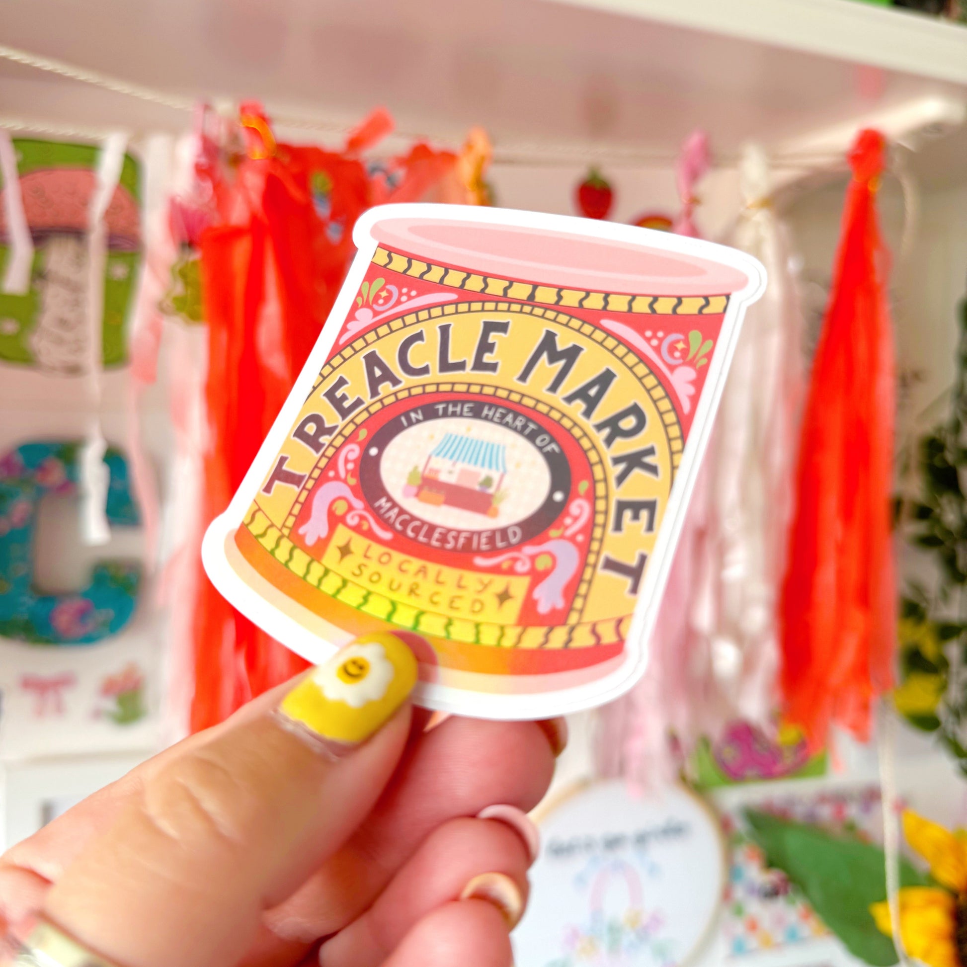 A holographic sticker of a jar of treacle, but it has been illustrated to represent the Treacle market which takes place once a month in the town of Macclesfield.
