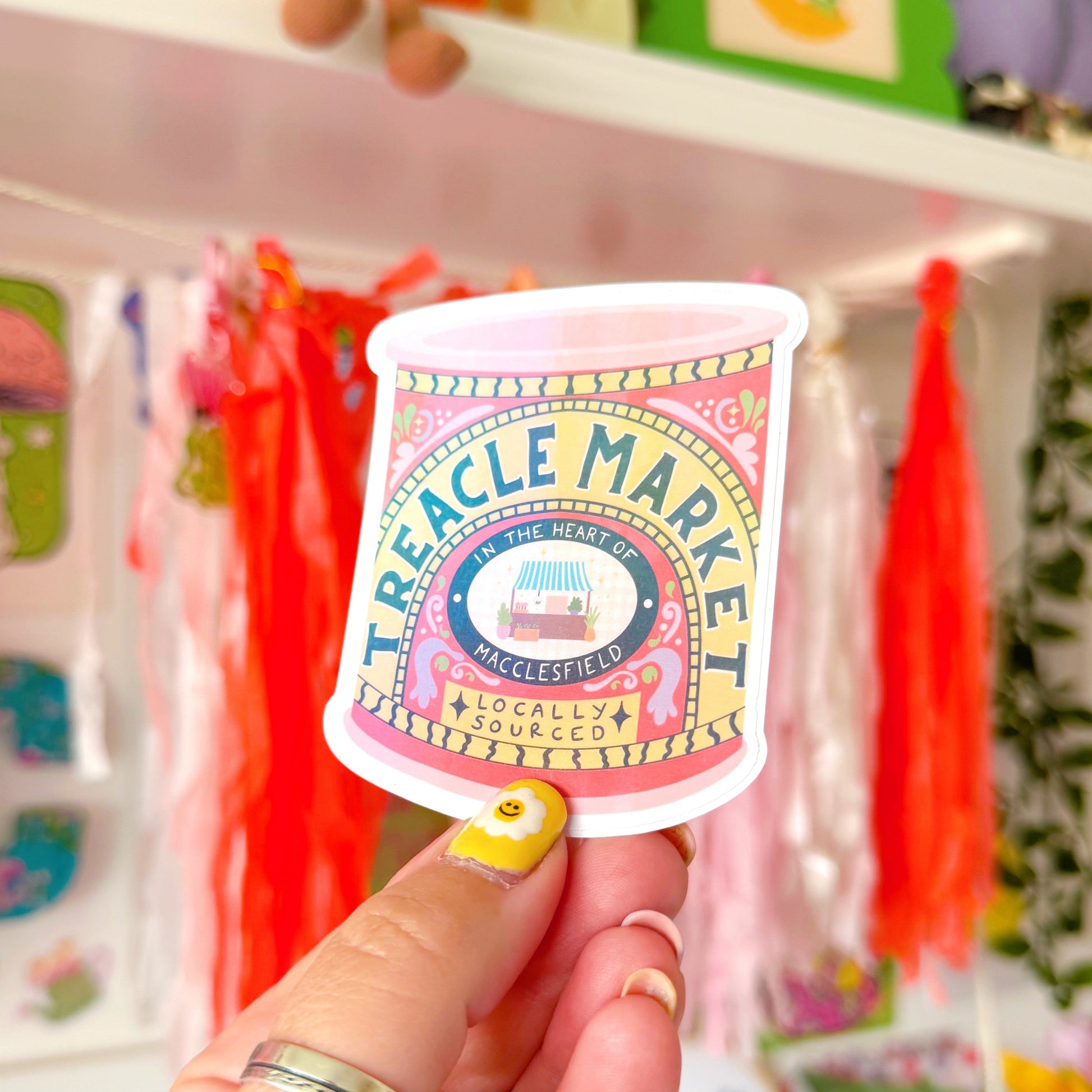 A holographic sticker of a jar of treacle, but it has been illustrated to represent the Treacle market which takes place once a month in the town of Macclesfield.