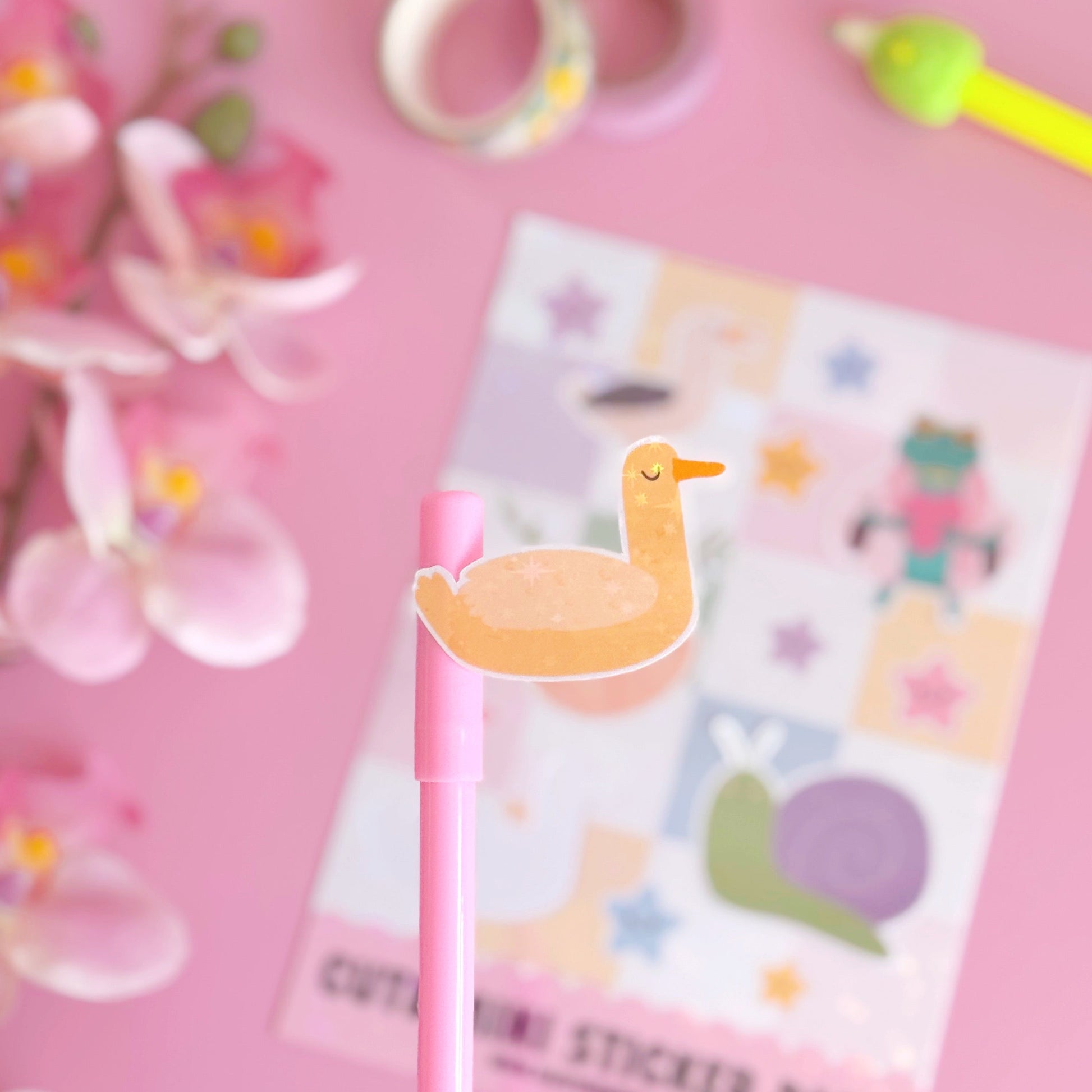 A sticker from the mini sticker pals sticker sheet. This is a yellow duck, coated with a holographic laminate with little starbursts on.