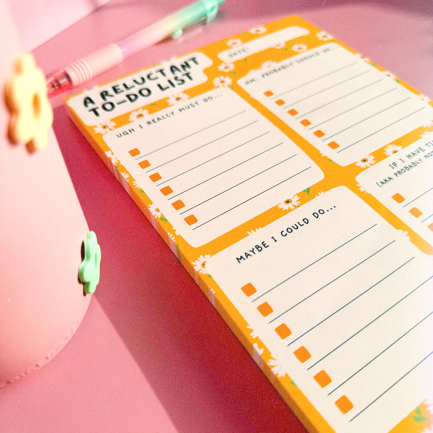 An image of an A5 yellow notepad, with funny headed sections. The notepad has a yellow floral background and four sections.