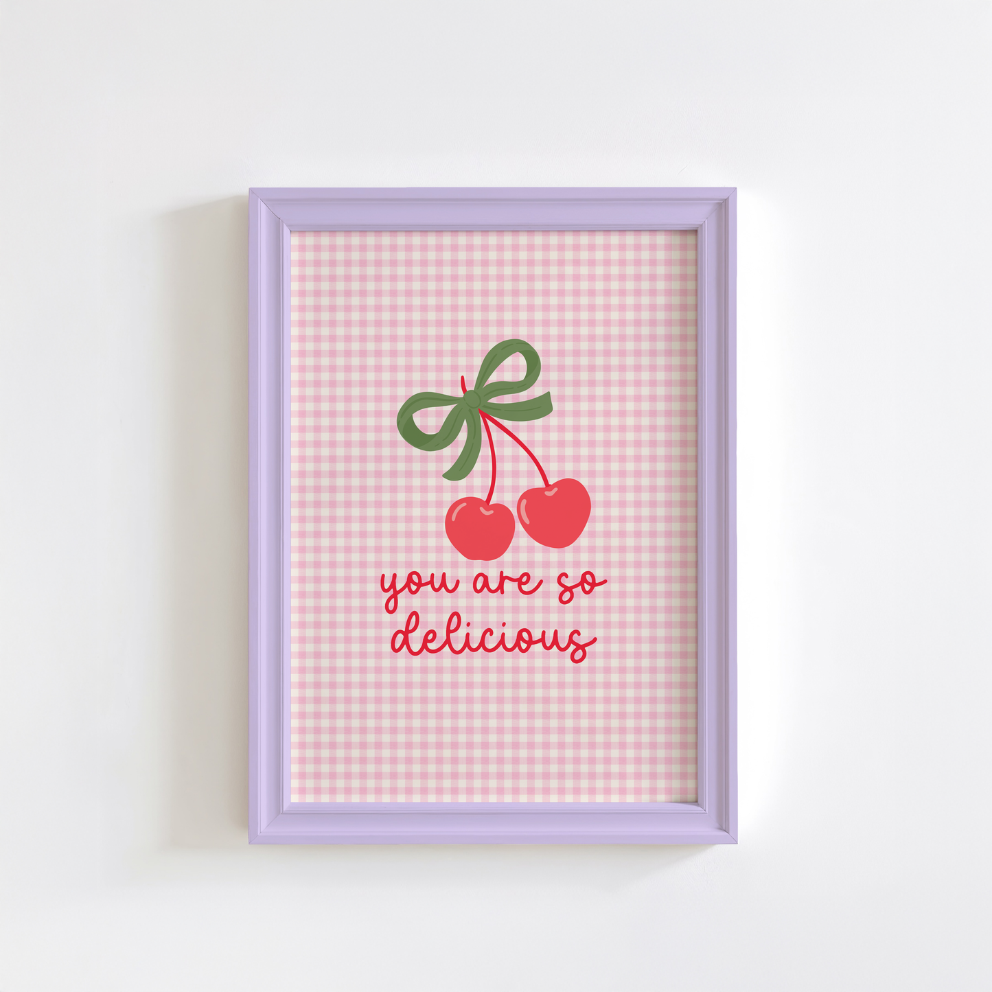 A pink gingham background print, with an illustration of red cherries tied together with a green bow, and the quote saying 'you are so delicious' below.