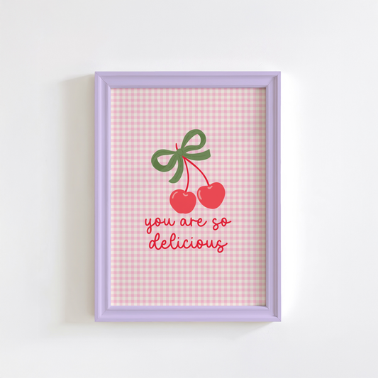 A pink gingham background print, with an illustration of red cherries tied together with a green bow, and the quote saying 'you are so delicious' below.