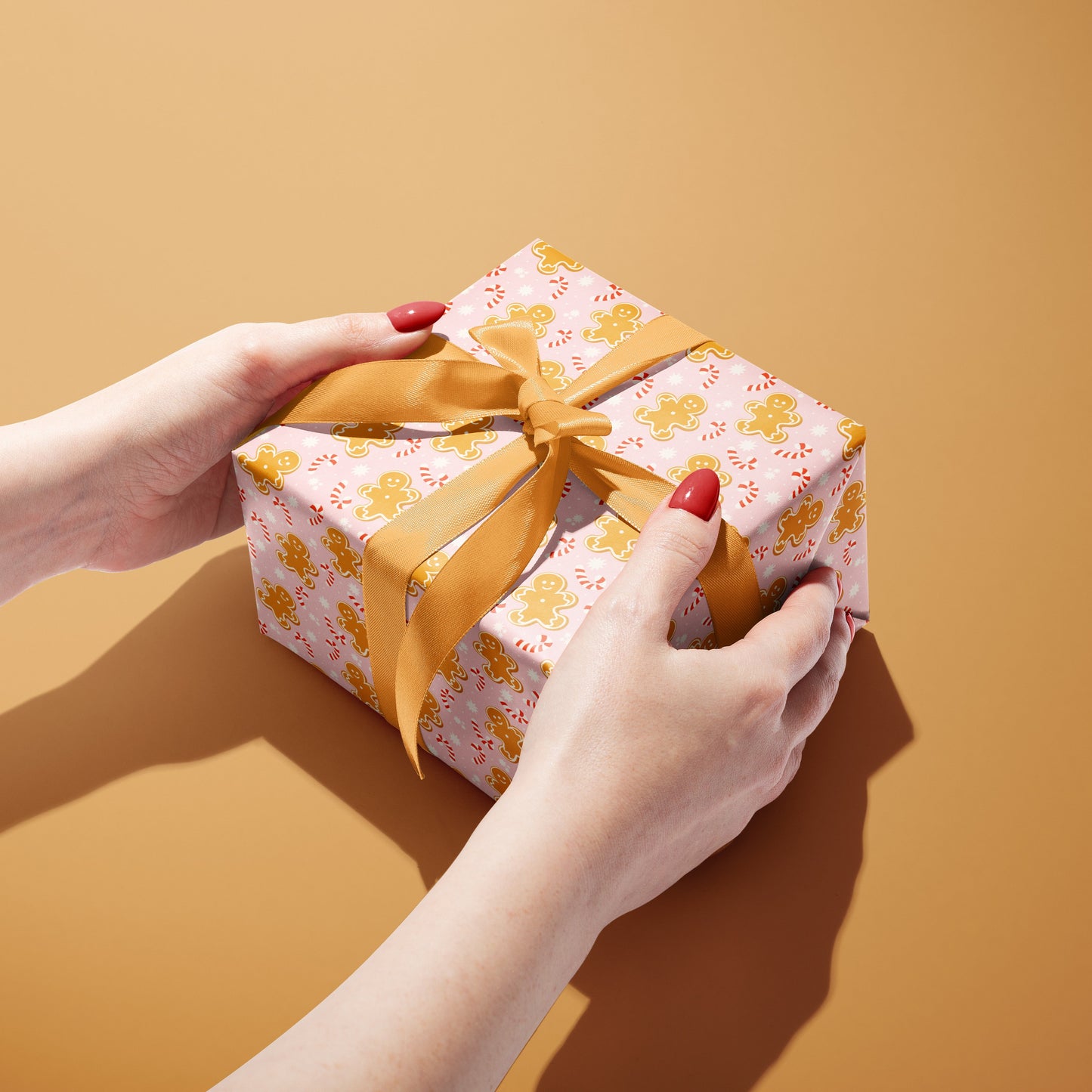 Gift box with a yellow ribbon held by hands against a brown background