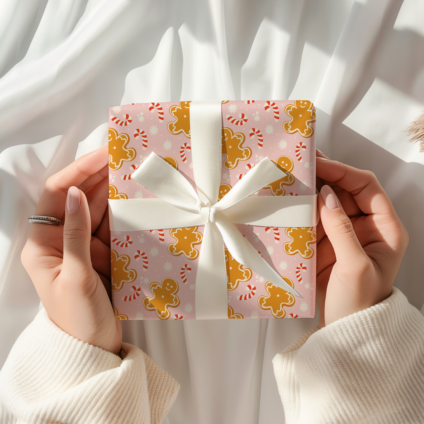 Gift box with a white ribbon held by hands against a white background